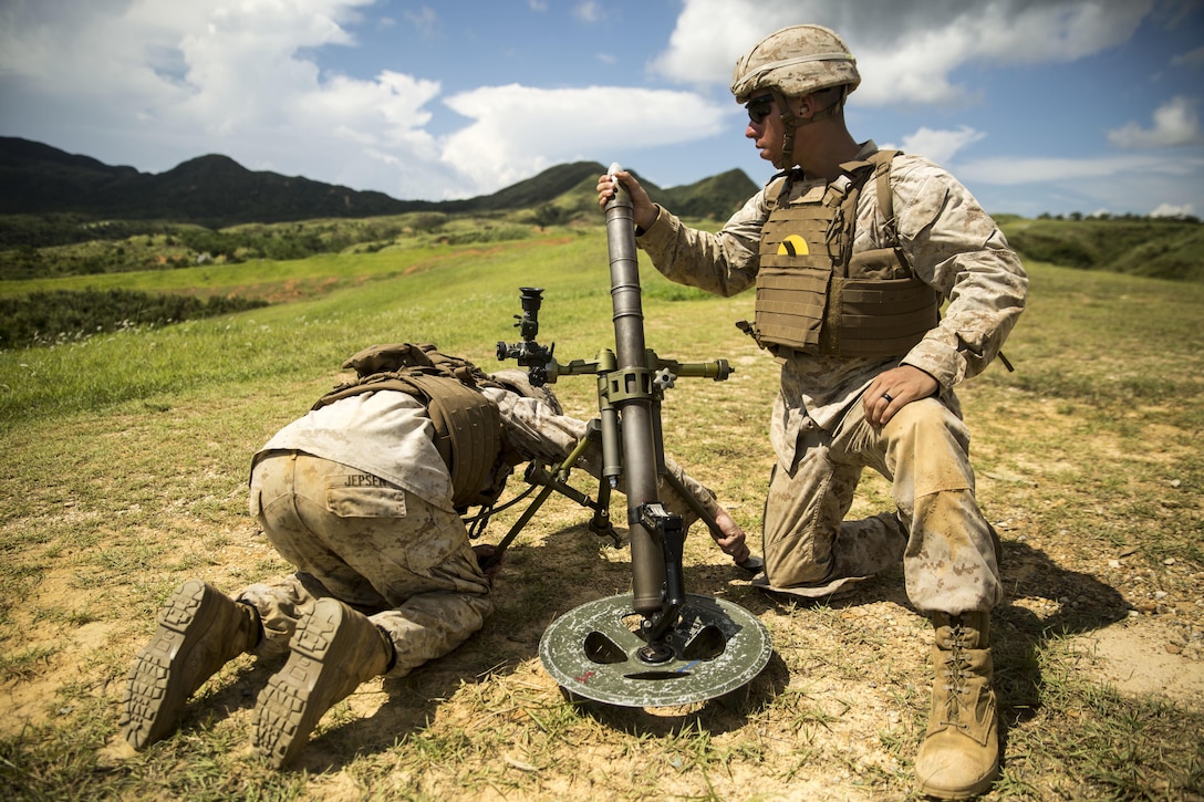 Cpl. Eric Pacheco, right, loads a 60 mm mortar as Cpl. Michael Jepsen steadies the weapon during the 3rd Marine Division Annual Squad Competition, Sept. 3, 2015. The competition allows Marines to enhance their infantry skills in a competitive environment. Pacheco, from Kansas City, and Jepsen, from Marion, Illinois, are mortarmen with Fox Company, 2nd Battalion, 3rd Marine Regiment, 3rd Marine Division. 