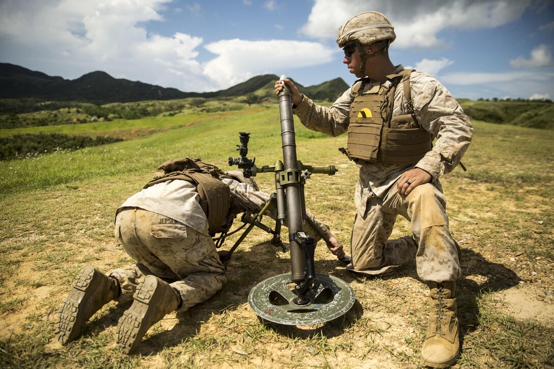 Cpl. Eric Pacheco, right, loads a 60 mm mortar as Cpl. Michael Jepsen steadies the weapon during the 3rd Marine Division Annual Squad Competition, Sept. 3, 2015. The competition allows Marines to enhance their infantry skills in a competitive environment. Pacheco, from Kansas City, and Jepsen, from Marion, Illinois, are mortarmen with Fox Company, 2nd Battalion, 3rd Marine Regiment, 3rd Marine Division. 