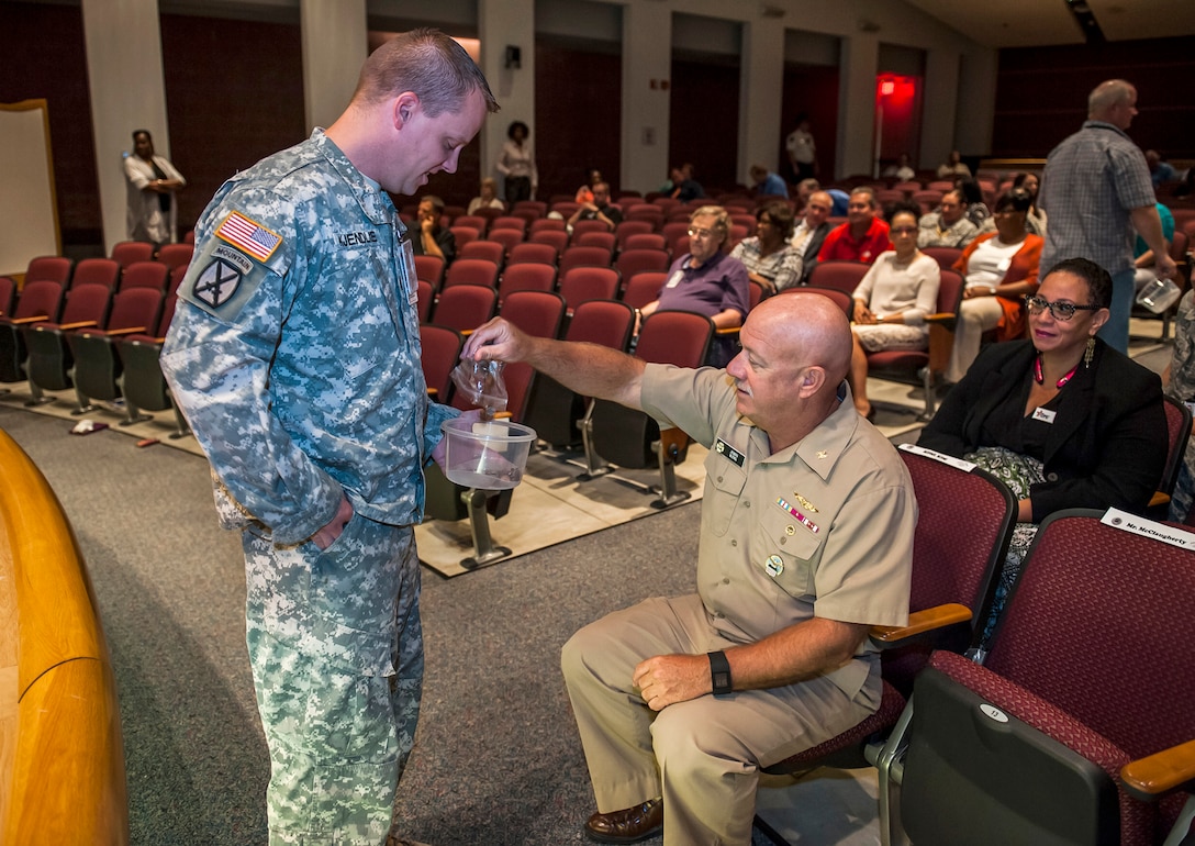 Navy RDML John King, DLA Land and Maritime commander, gives some loose change during Land and Maritime’s Combined Federal Campaign kickoff Sept. 10 inside the Building 20 auditorium. Attendees donated their loose change as part of the kickoff fundraiser to demonstrate that every cent counts when it comes to CFC. The campaign runs through Dec. 15.