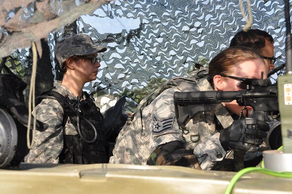 2nd Lt. Nabhira Mascarro, chaplain candidate, observes as Staff Sgt. Chelsea McLamore, radio frequency transmission system maintenance specialist and Senior Airman Michael Ashmead, cyber transport technician, provides security during the Chaplain Candidate Intensive Internship Field Exercise at the Combat Readiness School, Robins Air Force Base, Ga. July 13, 2015. Chaplain Candidates got a broad overview of military life by visiting different military installations and meeting with service members from all branches of the armed forces. (U.S. Air Force photo by Master Sgt. James Branch)