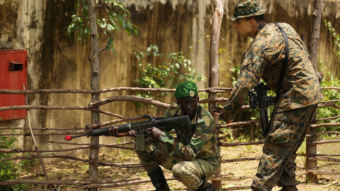 Cpl. Benjamin Swanson, a rifleman with Security Cooperation Team-4, Special-Purpose Marine Air-Ground Task Force Crisis Response-Africa, ‘bumps’ his Compagnie Fusilier de Marin Commando counterpart to signal him to cross the danger area with cover during a patrol exercise in Toubacouta, Senegal, Sept. 2, 2015. Marines, sailors and Coast Guardsmen with SCT-4 are in Senegal training with the COFUMACO on infantry tactics and small-boat operations to continue building a strong relationship between the partner nations and improve the interoperability of the Senegalese military. 