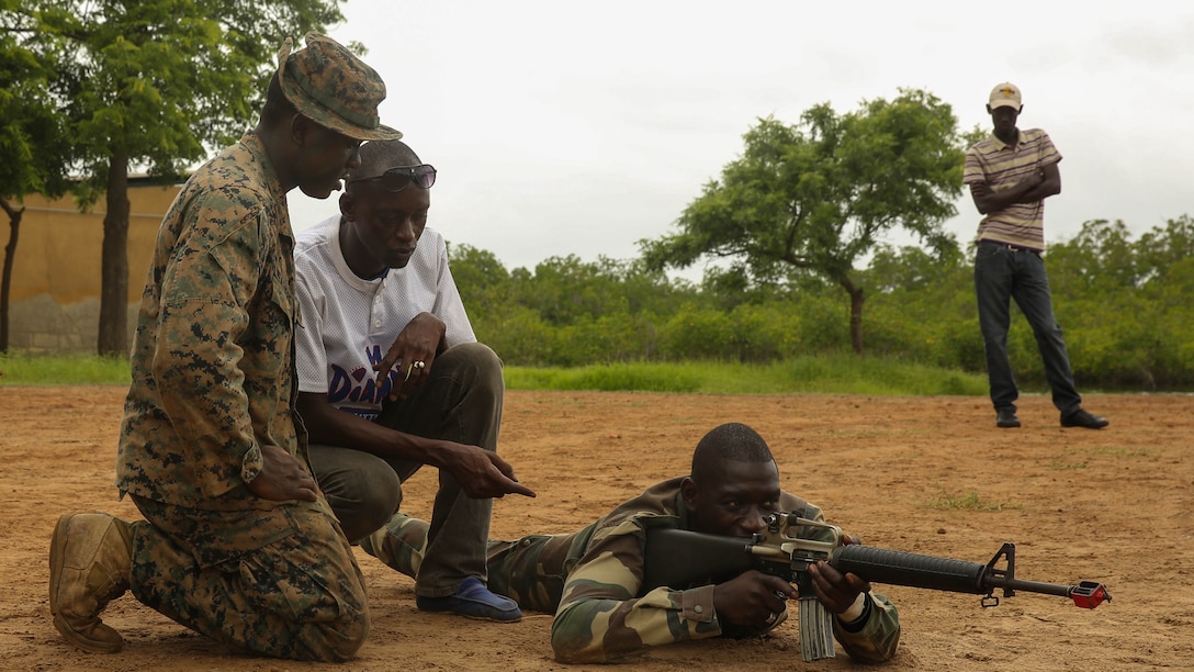 Lance Cpl. Trent Meade, a rifleman with Security Cooperation Team-4, Special-Purpose Marine Air-Ground Task Force Crisis Response-Africa, instructs a Compagnie Fusilier de Marin Commando on supporting his buddy during an immediate action practical application exercise led by Marines in Toubacouta, Senegal, Sept. 1, 2015. Marines, sailors and Coast Guardsmen with SCT-4 are in Senegal training with the COFUMACO on infantry tactics and small-boat operations to continue building a strong relationship between the partner nations and improve the interoperability of the Senegalese military.