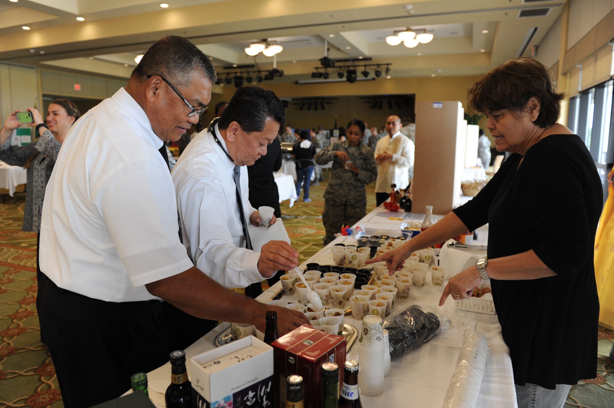 Lucy Belles, Asian Pacific American Heritage committee member, serves cultural food samplings to Keesler personnel at Diversity Day Sept. 15, 2015, at the Bay Breeze Event Center, Keesler Air Force Base, Miss. The cultural celebration also included a photo booth and booths with information about countries around the world and other special emphasis groups. (U.S. Air Force photo by Kemberly Groue)