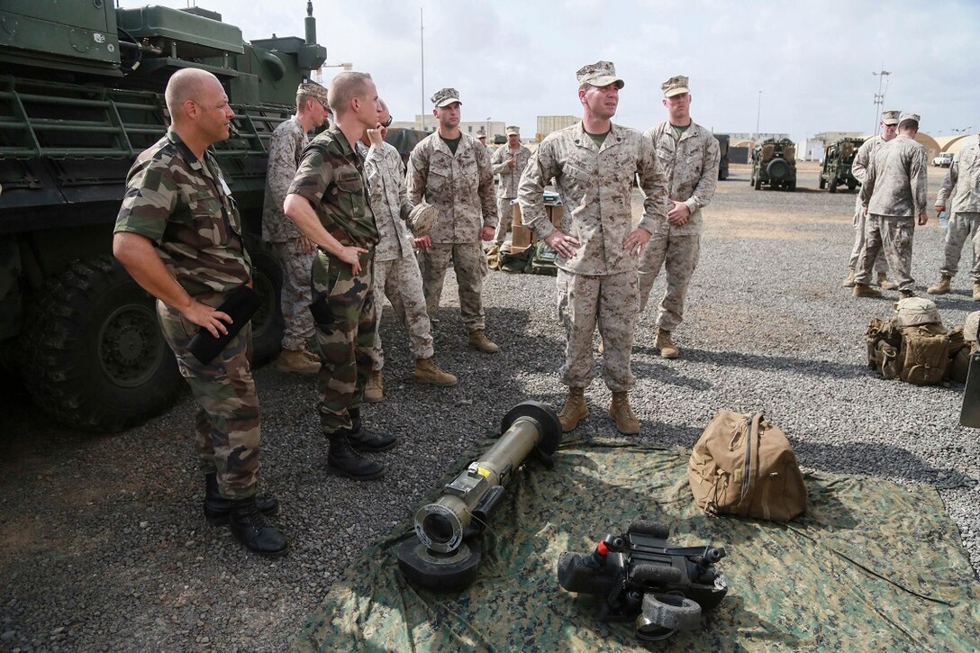 CAMP LEMONNIER, Djibouti (Sept. 9, 2015) U.S. Marine Sgt. Samuel Krebs, middle, prepares to explain the capabilities of his vehicle and weapon systems during a static display for French officers from the French 5th Overseas Combined Arms Regiment (RIAOM) gather around as. Krebs is a vehicle commander with Weapons Company, Battalion Landing Team 3rd Battalion, 1st Marine Regiment, 15th Marine Expeditionary Unit. Elements of the 15th MEU are preparing to conduct bilateral training with the 5th RIAOM in Djibouti in order to improve interoperability between the MEU and the French military. (U.S. Marine Corps photo by Sgt. Steve H. Lopez/Released)