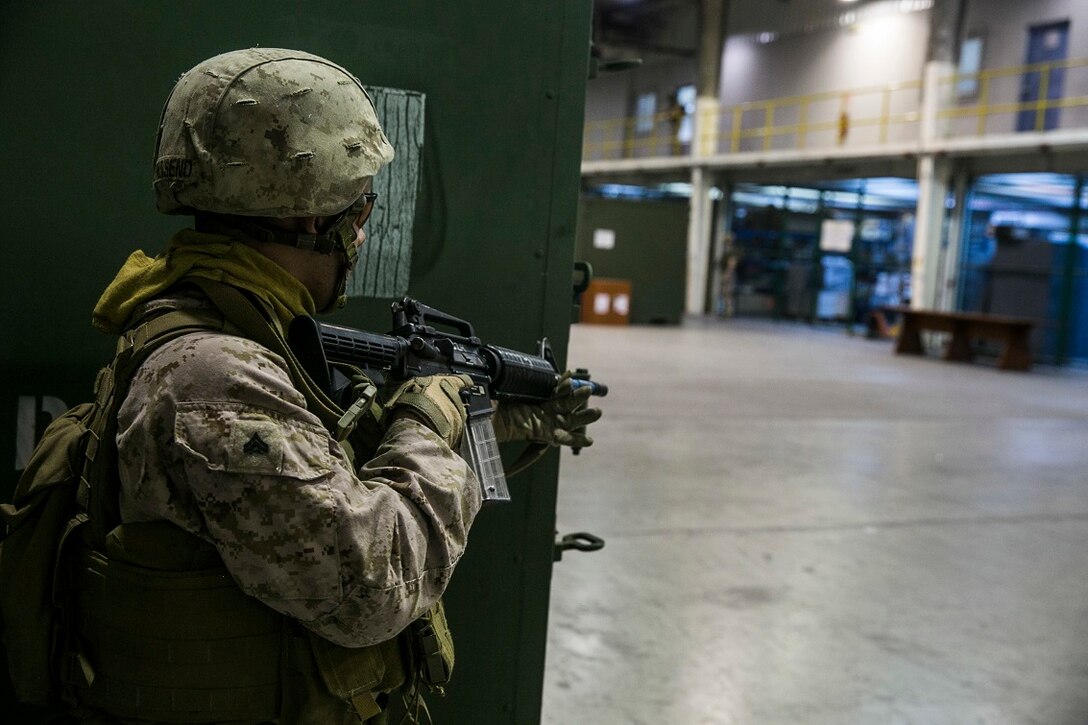NAVAL SUPPORT ACTIVITY BAHRAIN (Sept. 9, 2015) A U.S. Marine with the Fleet Anti-terrorism Security Team provides security while practicing close-quarter battle tactics aboard Naval Support Activity Bahrain. These Marines were sharing techniques, tactics, and procedures with the 15th Marine Expeditionary Unit’s Force Reconnaissance Detachment. The 15th MEU is embarked with the Essex Amphibious Ready Group and deployed to maintain regional security in the U.S. 5th Fleet area of operations. (U.S. Marine Corps photo by Cpl. Anna Albrecht/Released)