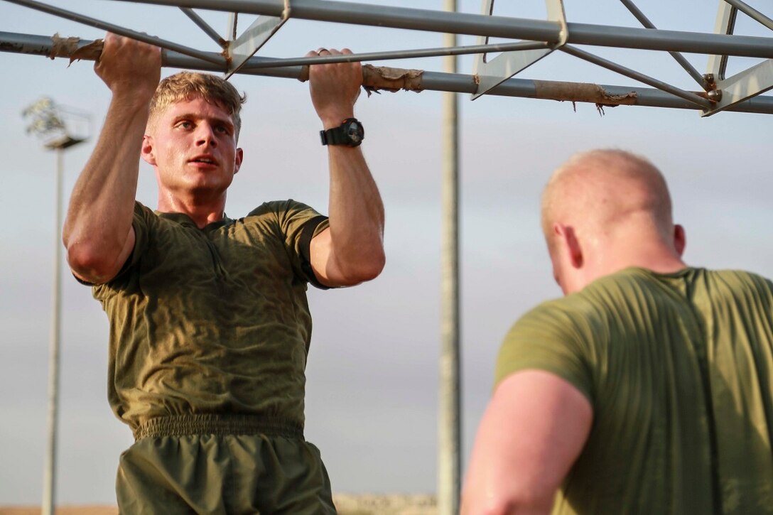 CAMP LEMONNIER, Djibouti (Sept. 11, 2015) U.S. Marine Lance Cpl. Jedediah Vance, left, does pulls ups during unit physical training. Vance is a gunner with Weapons Company, Battalion Landing Team 3rd Battalion, 1st Marine Regiment, 15th Marine Expeditionary Unit. The Marines use unit PT to acclimatize to Djibouti’s temperatures, and stay fit. Elements of the 15th MEU are preparing to conduct bilateral training with the 5th Overseas Combined Arms Regiment (RIAOM) in Djibouti in order to improve interoperability between the MEU and the French military. (U.S. Marine Corps photo by Sgt. Steve H. Lopez/Released)