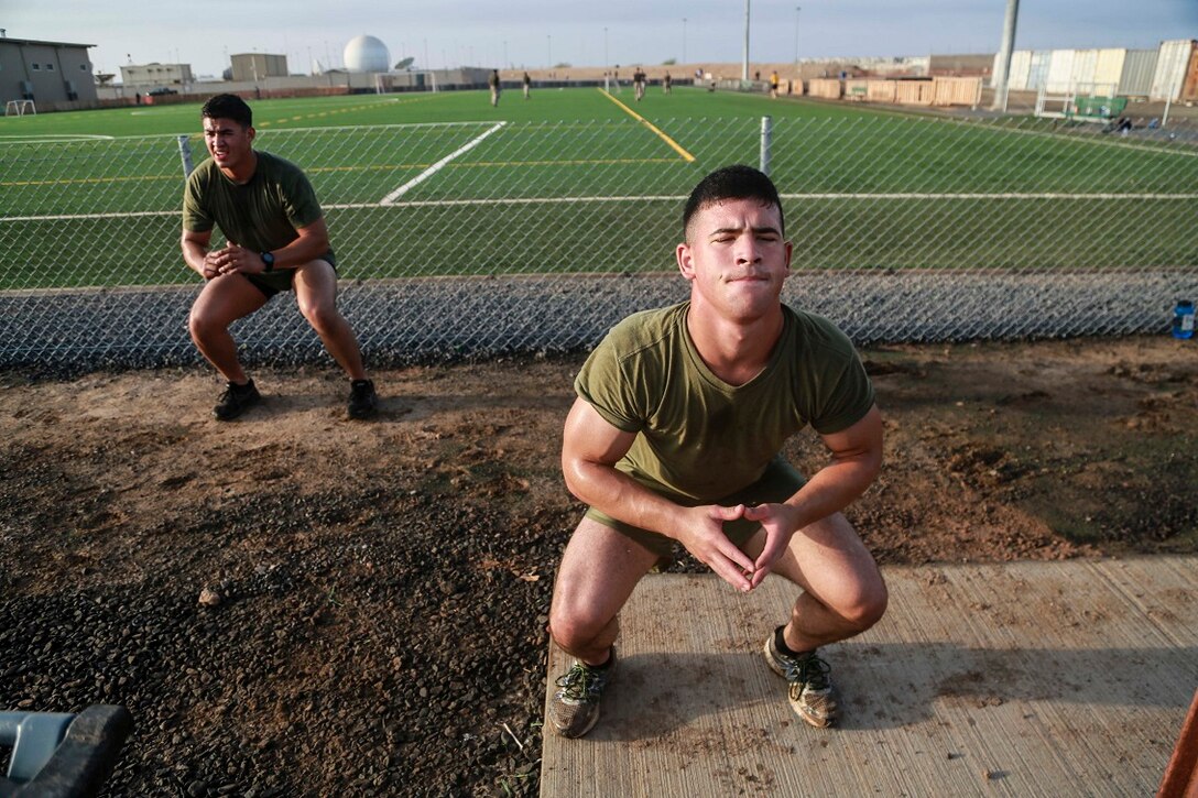 CAMP LEMONNIER, Djibouti (Sept. 11, 2015) U.S. Marine Lance Cpl. George Camden, right, performs squats during unit physical training. Camden is a driver with Weapons Company, Battalion Landing Team 3rd Battalion, 1st Marine Regiment, 15th Marine Expeditionary Unit. The Marines use unit PT to acclimatize to Djibouti’s temperatures, and stay fit. Elements of the 15th MEU are preparing to conduct bilateral training with the 5th Overseas Combined Arms Regiment (RIAOM) in Djibouti in order to improve interoperability between the MEU and the French military. (U.S. Marine Corps photo by Sgt. Steve H. Lopez/Released)