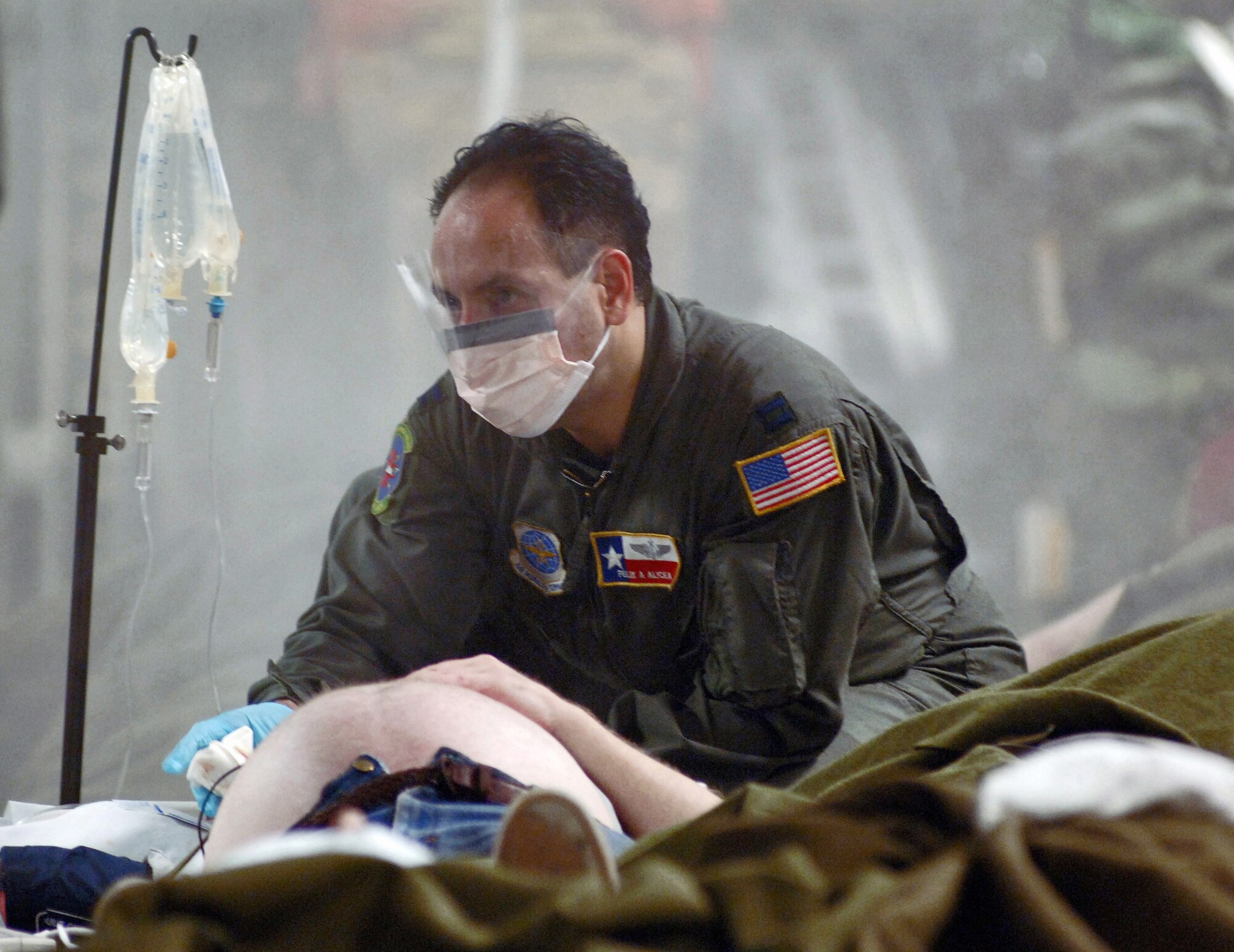 U.S. Air Force Capt. Felix A. Alicia, a flight nurse with the Critical Care Air Transport Team from the 433rd Aeromedical Evacuation Squadron, Lackland Air Force Base, Texas, treats a Hurricane Katrina victim before a medical evacuation mission onboard a C-17 Globemaster III cargo aircraft from the 62nd Airlift Wing, McChord Air Force Base, Wash., at the Louis Armstrong New Orleans International Airport, La., on Sept. 1, 2005.  (U.S. Air Force photo by Master Sgt. Lance Cheung) (Released)