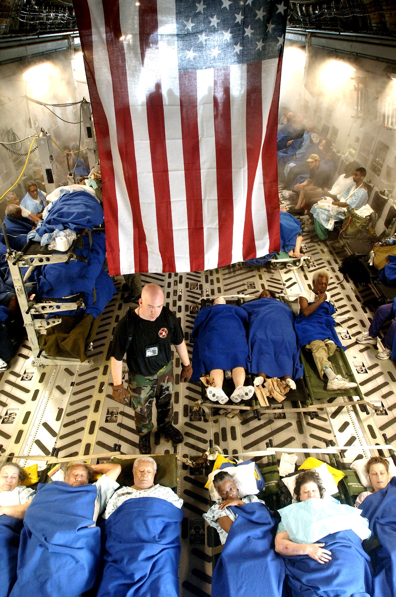 Sick and injured people are prepared and comforted for a flight aboard a C-17 Globemaster III of the 62nd and 446th Airlift Wing, McChord Air Force Base. The aircraft and crew have stoped at the New Orleans International Airport on 1 Sept, 2005. These refugees from hospitals and various sources are evacuating the devastated areas left by Hurricane Katrina. Their destination will be an Air Force Base in a state in southern region not affected. Critical Care Aeromedical Teams cared for hundreds of patients on this day. (U.S. Air Force photo Master Sgt. Lance Cheung)