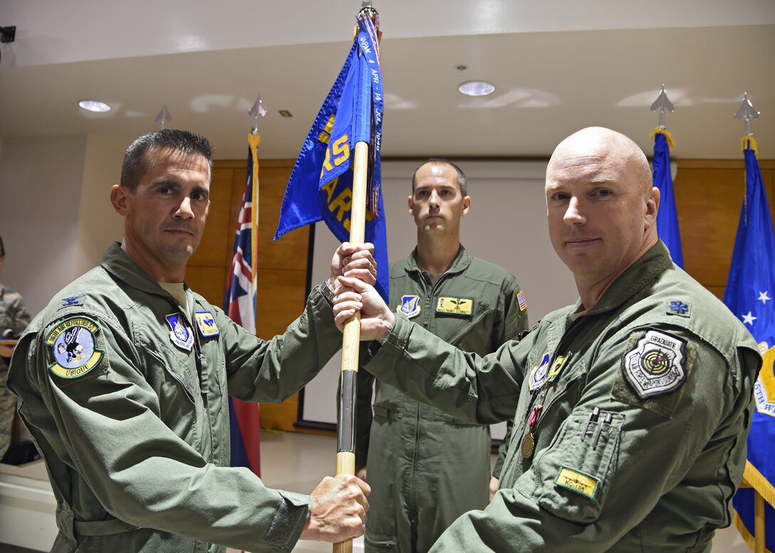 U.S. Air Force Col. Charles Velino (left), 15th Operations Group commander, receives the guidon as Lt. Col. Jason Work, 96th Air Refueling Squadron commander, relinquishes command during the 96th ARS deactivation ceremony on Joint Base Pearl Harbor-Hickam, Hawaii, Sept. 3, 2015. The 96th Air Refueling Squadron was reactivated on July 23, 2010, at Joint Base Pearl Harbor Hickam, in response to an increased demand for in-flight air refueling support throughout the Pacific theater. Since its reactivation, the 96th Air Refueling Squadron flew more than 1,800 sorties, totaling over 6,500 hours and offloading more than 36-million pounds of fuel to thousands of joint and multinational aircraft. (U.S. Air Force photo by Tech. Sgt. Aaron Oelrich/Released)