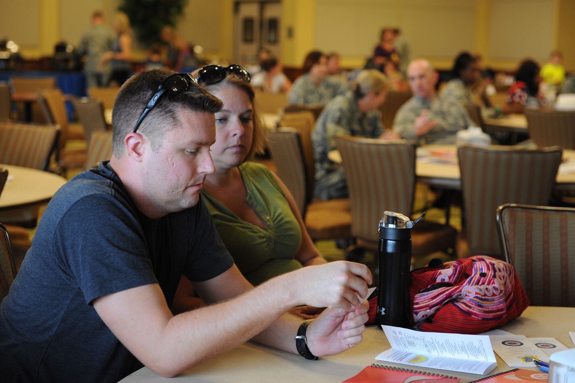 Capt. Jonathan Ely, 81st Logistics Readiness Squadron operations officer and his spouse, Nicole, read Keesler community support literature during the Keesler family town hall forum Sept. 15, 2015, at the Bay Breeze Event Center, Keesler Air Force Base, Miss. The forum was hosted by Col. Michele Edmondson, 81st Training Wing commander, to discuss current wing topics followed by a question and answer session. (U.S. Air Force photo by Kemberly Groue)