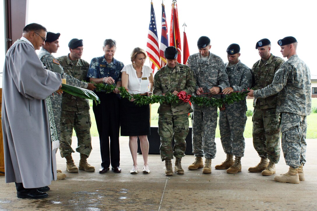 Brig. Gen. Jeffrey L. Milhorn, Commander Pacific Ocean Division, U.S. Army Corps of Engineers, (center) is assisted in the traditional maile lei untying and ribbon-cutting ceremony  by Lt. Col. Christopher W. Crary, Commander, U.S. Army Corps of Engineers-Honolulu District (third from left,) Mr. Len Housley, Deputy Commander U.S. Army Garrison-Hawaii (fourth from left),  Mrs. Sally Pfenning, Director, Directorate of Public Works, USAG-HI (fifth from left), Lt. Col. Michael Binetti, Commander, 29th Brigade Engineer Battalion (fourth from right),  Maj. Chris Izquierdo, Executive Officer, 19th Military Police (CID) Battlion (third from right), and Capt. Michael Simmons, Commander, A Company, 249th Engineer Battalion (Prime Power) (second from right). The Rev. Sherman Thompson (left) led the Hawaiian blessing and maile lei ribbon untying cutting ceremony. 