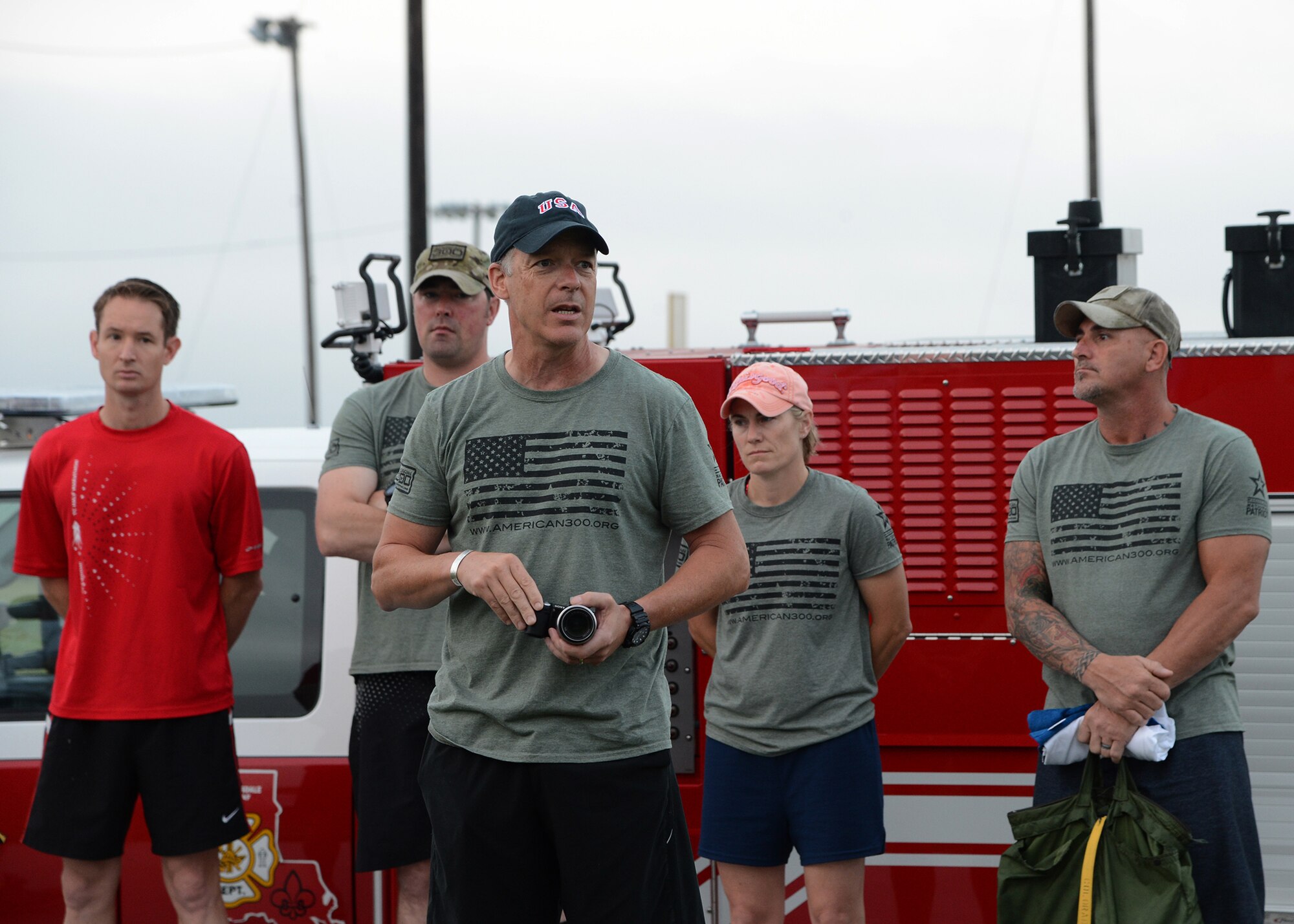 Robi Powers, center, American 300 Warrior Tours founder, speaks to members of Team Barksdale during the Sept. 11, remembrance 5K Run at Barksdale Air Force Base La., Sept. 11, 2015. Powers spoke about being resilient and honoring those whose lives lost on this day 14 years earlier. (U.S. Air Force photo/Senior Airman Joseph A. Pagán Jr.) 