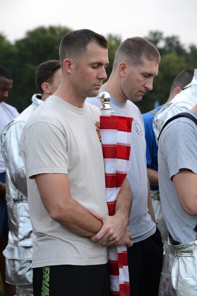Members of Team Barksdale participate in a moment of silence during the Sept. 11, remembrance 5K Run on Barksdale Air Force Base La., Sept. 11, 2015. Every month the Senior Airman Bryan Bell Fitness Center hosts a base 5k with a different theme to promote wellness and fitness. (U.S. Air Force photo/Senior Airman Joseph A. Pagán Jr.) 
