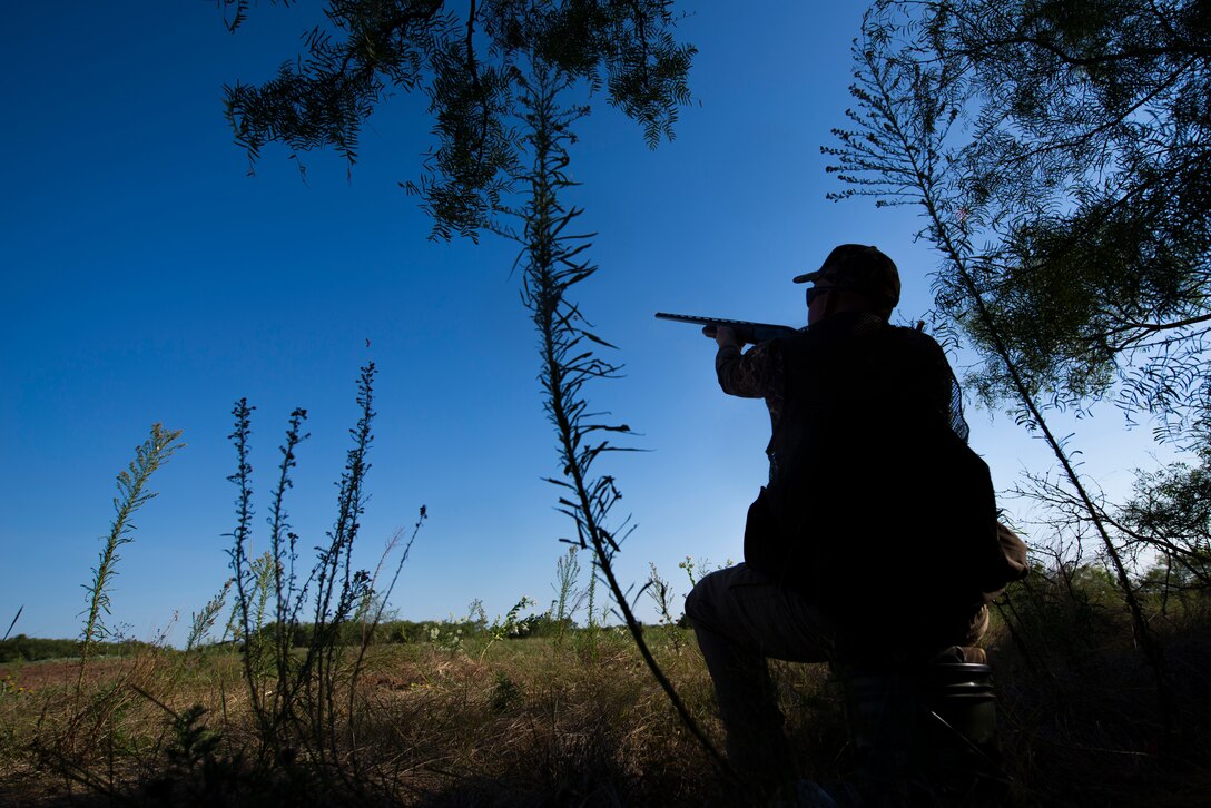 Staff Sgt. Daniel Cole, 364th Training Squadron instructor, points his shotgun at a dove passing by during the dove hunt portion of the Clay County Dove Salute in Henrietta, Texas, Sept. 12, 2015. Airmen were invited to the Birdwell and Clark Ranch to participate in dove hunt and a Texas-style steak dinner. (U.S. Air Force photo by Senior Airman Kyle Gese/Released)