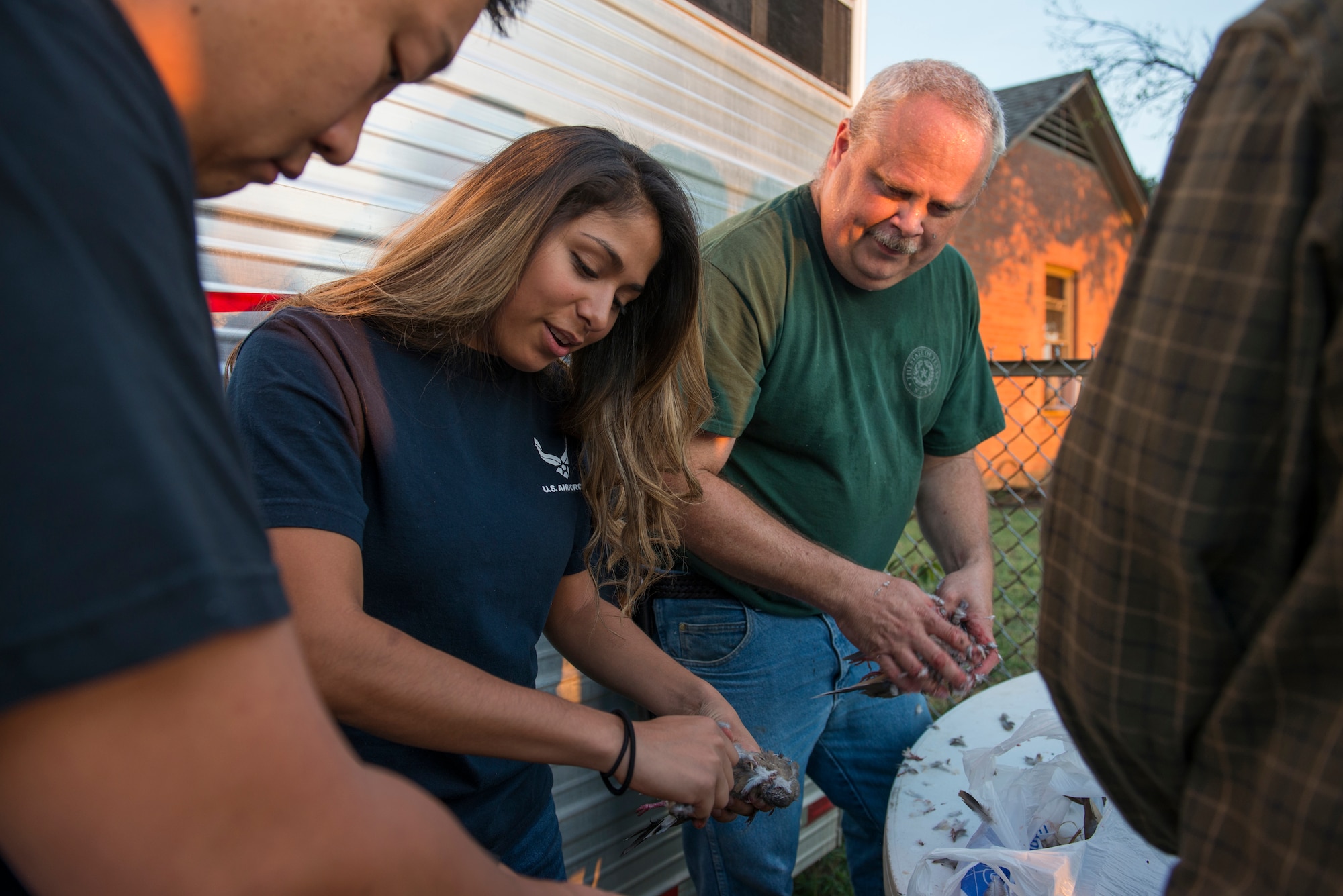 Senior Airman Danielle Baumann, 82nd Aerospace Medicine Squadron aerospace physiology technician, cleans dove after the 11th Annual Clay County Dove Salute on the Birdwell and Clark Ranch in Henrietta, Texas, Sept. 12, 2015. The Dove Salute welcomed Airmen to the community with a hunt and Texas-style steak feast on the Birdwell and Clark Ranch, with a closing thank you from the ranchers. (U.S. Air Force photo by Senior Airman Kyle Gese/Released)