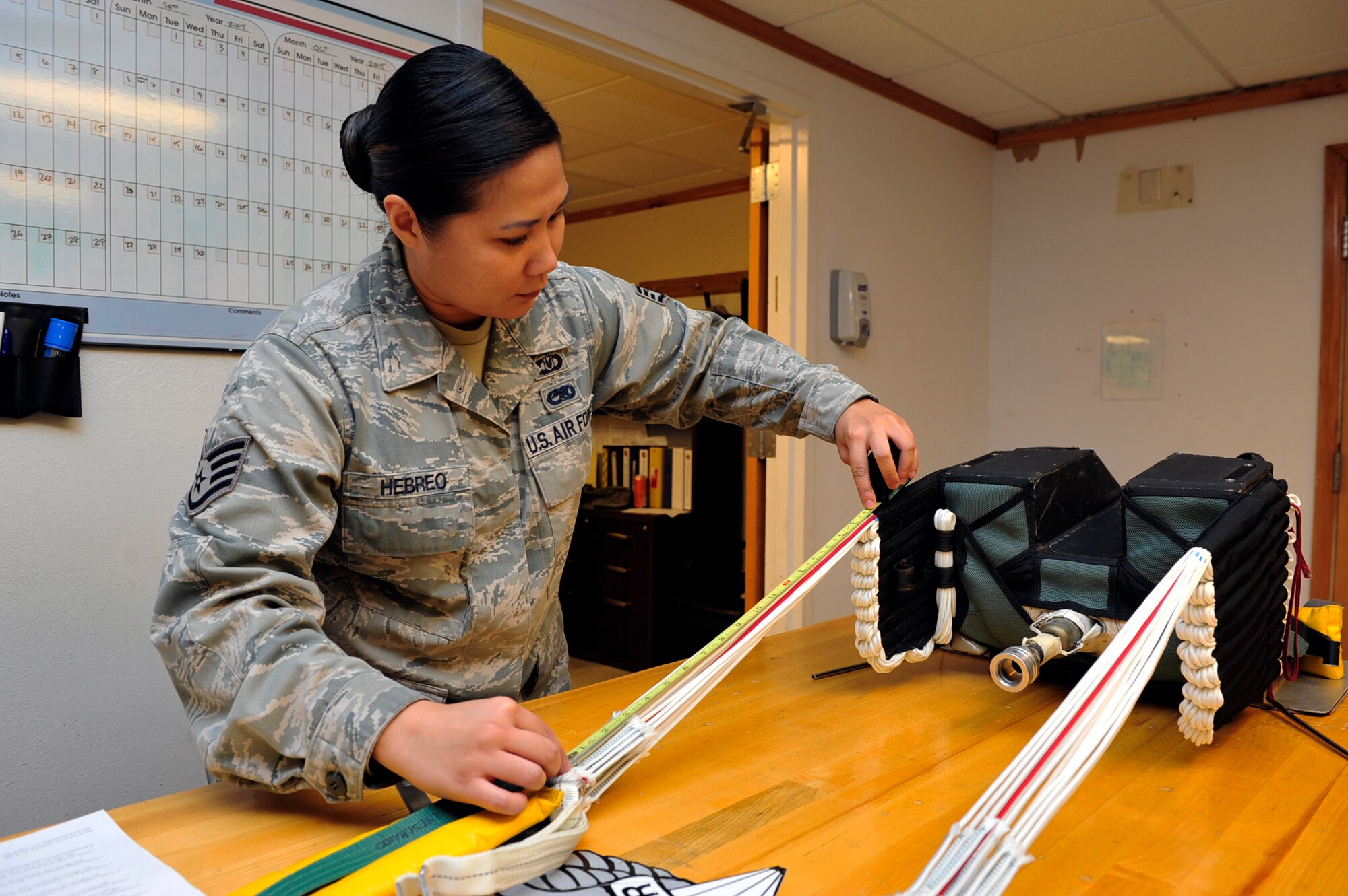 Staff Sgt. Marianne Hebreo, 56th Operations Support Squadron Aircrew Flight Equipment technician, verifies the stowing of the parachute’s suspension lines Sept. 14, 2015 in the AFE building at Luke Air Force Base, Arizona. Conducting an inspection on a parachute is a two-person job and requires great attention to detail, because missing one step could lead to a malfunction when deployed. (U.S. Air Force photo by Senior Airman Grace Lee)