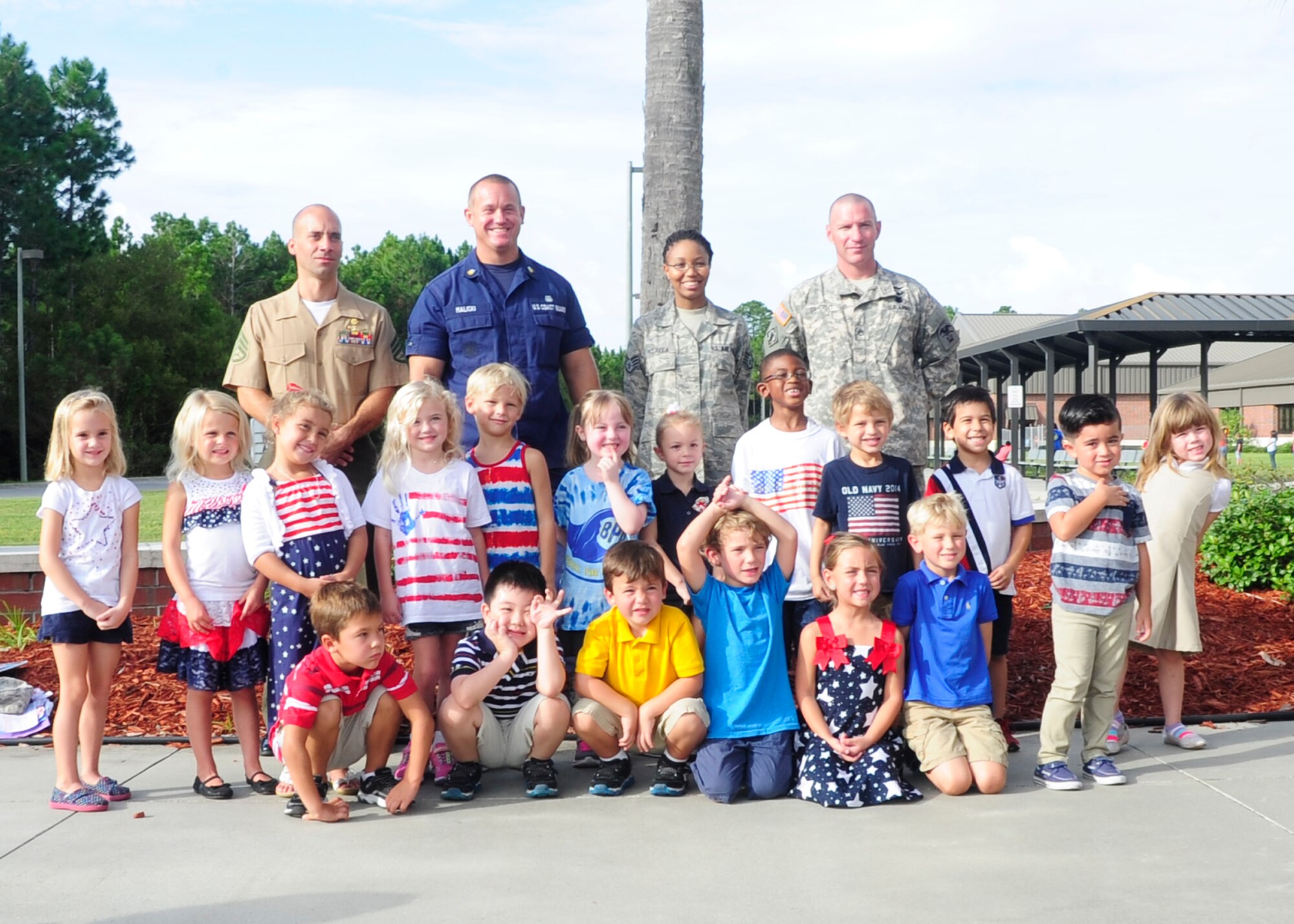 Service members pose for a picture with students from Breakfast Point Academy Sept. 11 after a flag raising ceremony and memorial to those lost during the terrorist attacks of 9/11. The school had more than 1,200 students and teachers that attended of this event.  (U.S. Air Force photo by Airman 1st Class Solomon Cook/Released)