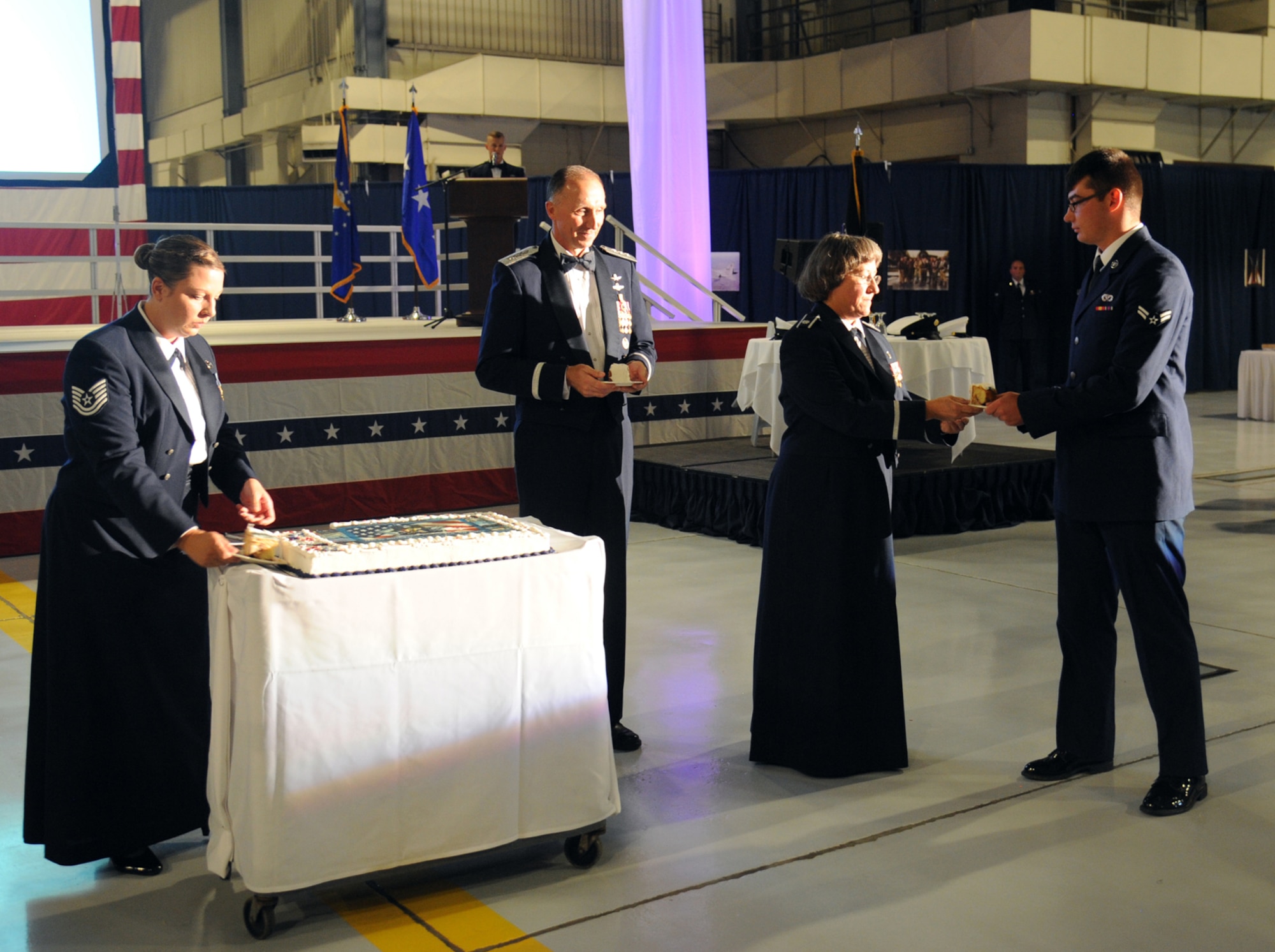 A slice of birthday cake is passed out to Lt. Gen. William Bender, Lt. Col. Debra McCarty and Airman 1st Class Levi Ehrhart during the Air Force Ball Sept. 11, 2015, at Grand Forks Air Force Base, North Dakota. McCarthy and Ehrhart received the first slices of birthday cake as the oldest and youngest Airmen in attendance at the event. As guest speaker for the event, Bender also received a piece. (U.S. Air Force photo by Senior Airman Desiree Economides/Released)