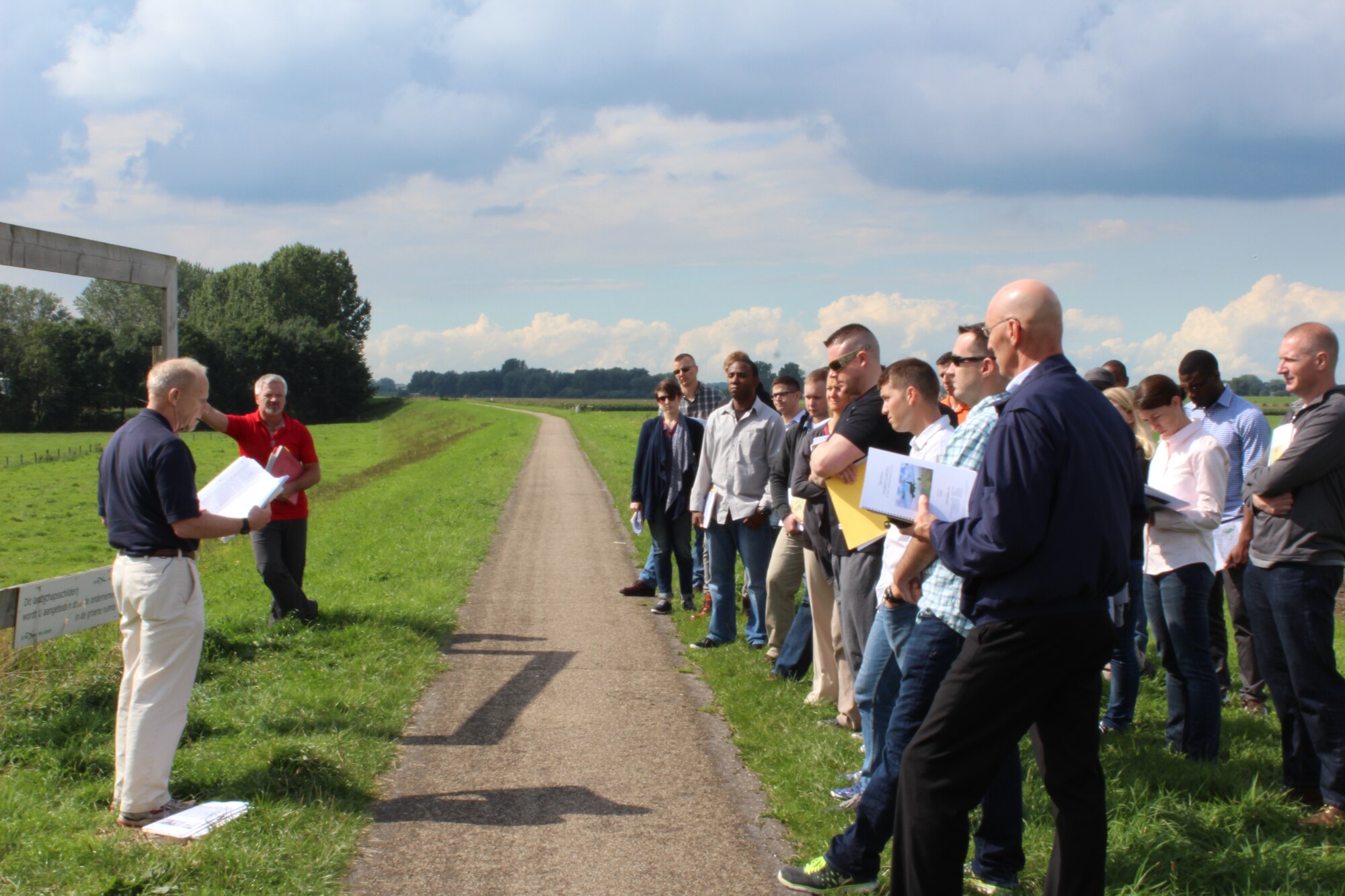 Participants of the Operation Market Garden staff ride listen to a lecture, Sept. 2, 2015, by staff ride leaders, Mr. Peter Herrly (left) and Dr. Ernest Roth (right) while standing at one of the many drop zones along Route 69 in the Netherlands that were used during the operation. This DZ was one of the many sites that airmen participating in the Operation Market Garden staff ride stopped to see along their route. The staff ride was part of a series that General Frank Gorenc, Commander, U.S. Air Forces in Europe, U.S. Air Forces in Africa, has organized to foster the deliberate professional development of USAFE-AFAFRICA airmen. (U.S. Air Force photo/ Capt. Lauren Ott)
