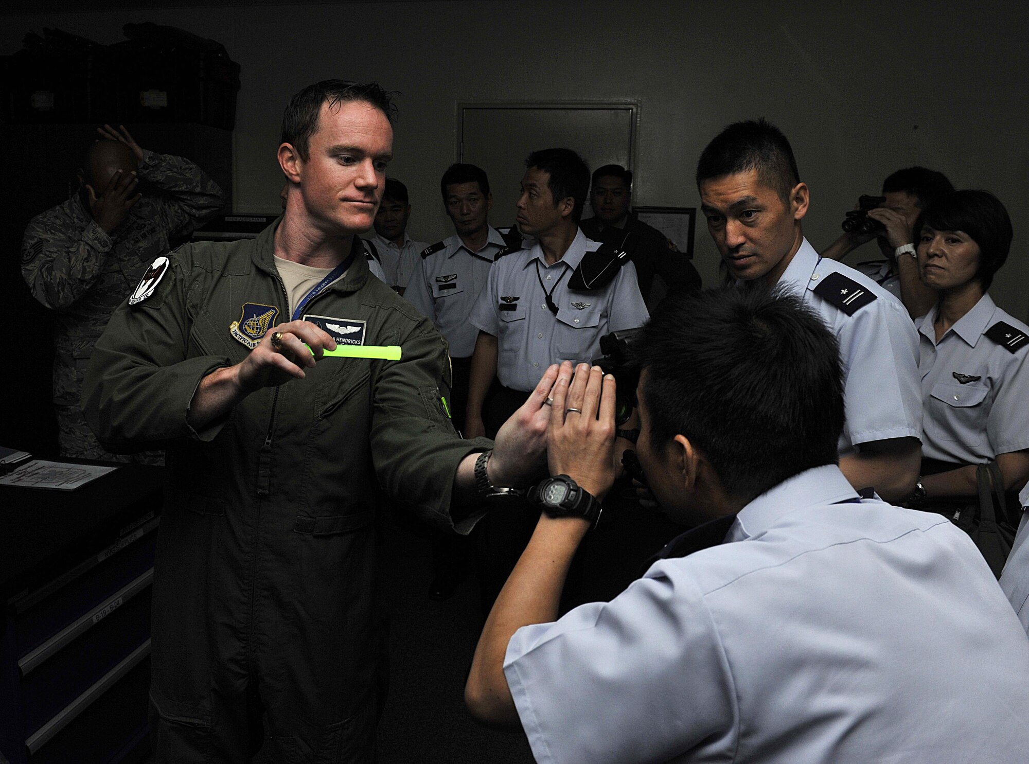 U.S. Air Force Capt. Steven Hendricks, 44th Fighter Squadron F-15 Eagle pilot, shows night vision goggles to a Japan Air Self-Defense Force officer during a tour Sept. 16, 2015, on Kadena Air Base, Japan. The tour gave the JASDF officers a better understanding of the missions and operations of U.S. military aircraft on Kadena. (U.S. Air Force photo by Naoto Anazawa) 