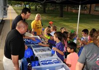 Shawn W. Leach, 319th Civil Engineer Squadron emergency management specialist, front, and Staff Sgt. Scott J. Tucker, 319th CES emergency management NCO-in-charge of logistics, hand out knick-knacks to Larimore Elementary School students Sept. 16, 2015, in Larimore, North Dakota. Leach and Tucker were part of the Grand Forks Air Force Base Emergency Management team that visited the school for National Preparedness Month. (U.S. Air Force photo by Airman 1st Class Ryan Sparks/Released)