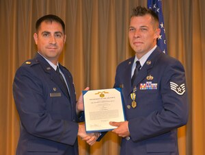 Major Robert Wryder Jr., 437th Aircraft Maintenance Squadron commander, presents the Air Force Commendation medal to SSgt. Marcus Williams, a 437th AMXS hydraulics craftsman, in the 437th AMXS auditorium at Joint Base Charleston – Air Base, Sept. 16, 2015. Williams received this reward for saving a civilian’s life after a motorcycle accident. (U.S. Air Force photo/Airman 1st Class Thomas T. Charlton)