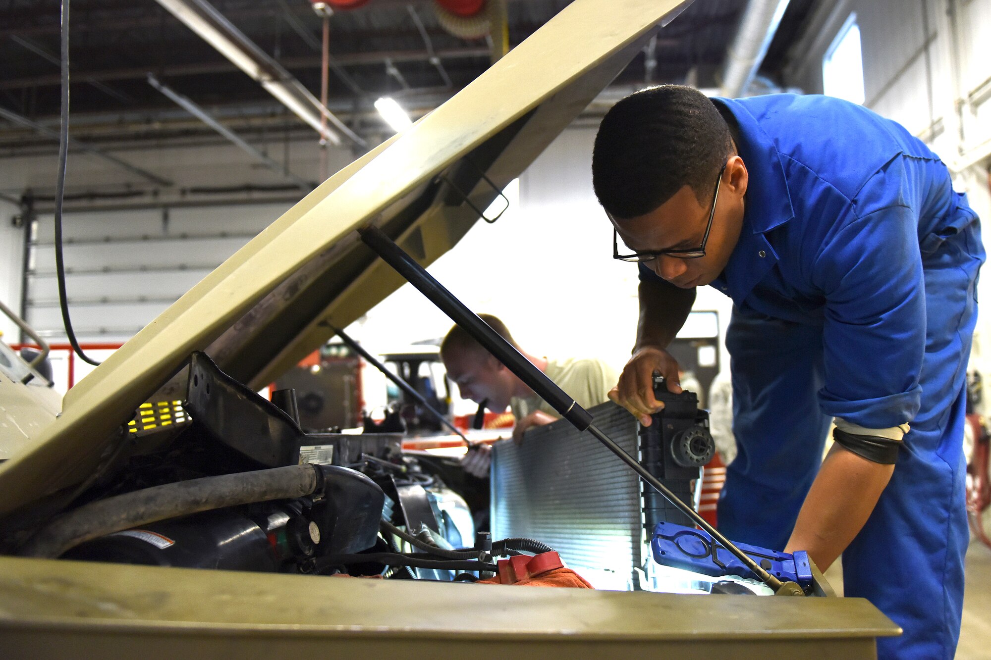 Senior Airman Ivan Slaughter, right, and Airman 1st Class Montgomery Martinson, 341st Logistics Readiness Squadron vehicle maintenance technicians, install a radiator into a Bearcat Sept. 15, 2015, at Malmstrom Air Force Base, Mont. In the month of August, the base’s Humvee and Bearcat armored vehicles, which are large and built to withstand enemy attack, spent more than 19,500 hours on the road. (U.S. Air Force photo/Chris Willis)