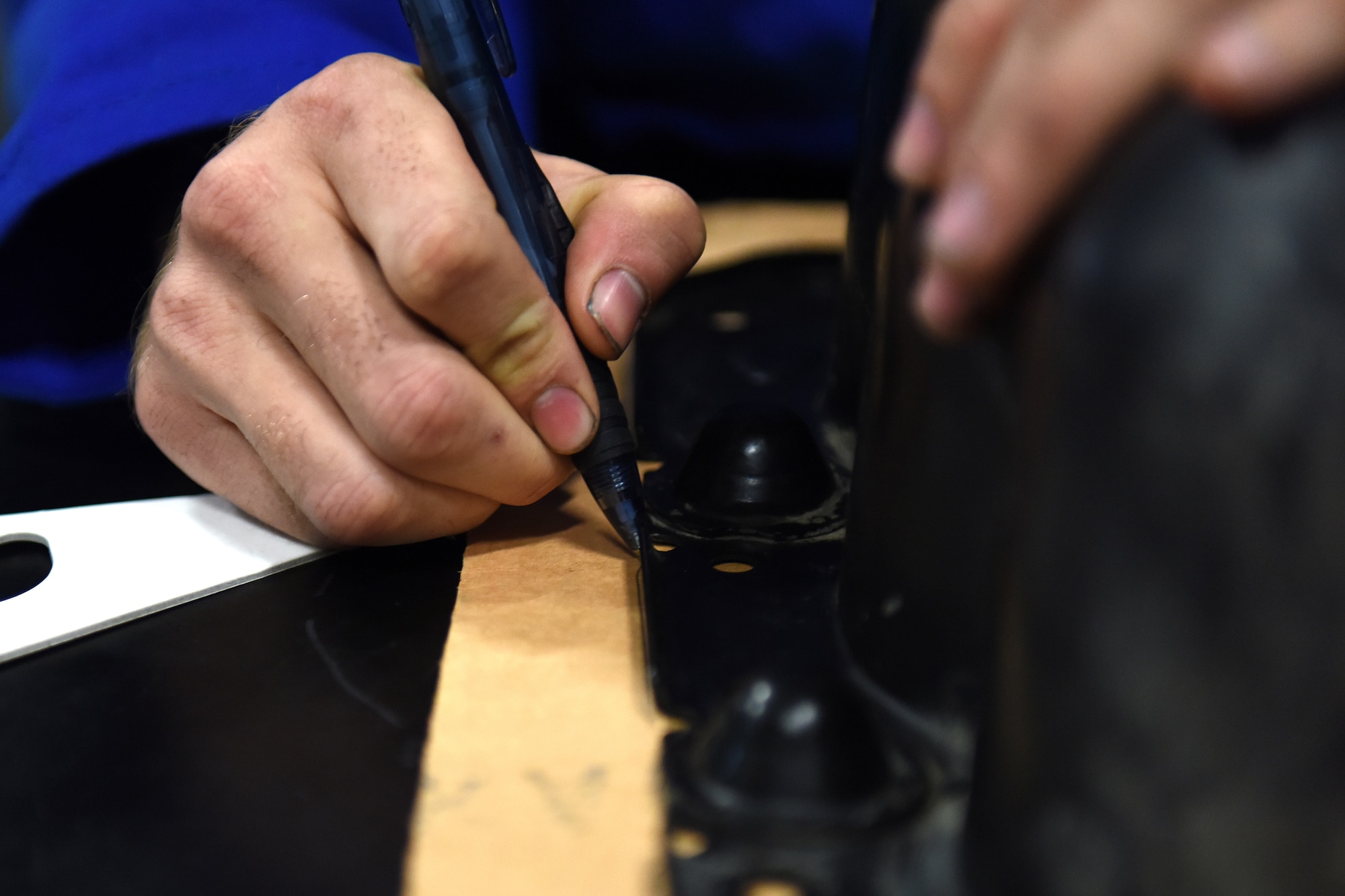 Airman 1st Class Tyler Lotspeich, 341st Logistics Readiness Squadron vehicle maintenance technician, outlines a gasket for an oil pan Sept. 15, 2015, at Malmstrom Air Force Base, Mont. An average of 14 personnel at the heavy equipment shop upkeep these vehicles year-round, sometimes pulling 12-hour shifts for 24-hours. (U.S. Air Force photo/Chris Willis)