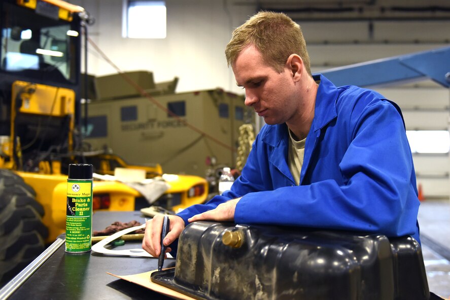 Airman 1st Class Tyler Lotspeich, 341st Logistics Readiness Squadron vehicle maintenance technician, outlines a gasket for an oil pan Sept. 15, 2015, at Malmstrom Air Force Base, Mont. An average of 14 personnel at the heavy equipment shop upkeep these vehicles year-round, sometimes pulling 12-hour shifts for 24-hours. (U.S. Air Force photo/Chris Willis)