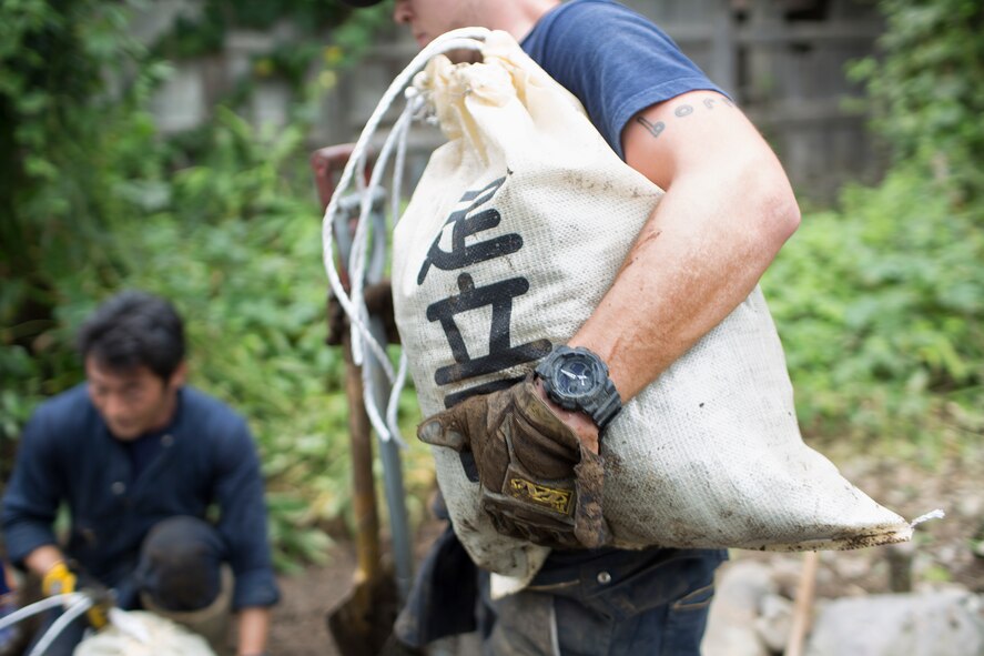 Airman 1st Class Zachary Schofield, 374th Civil Engineer Squadron firefighter, carries a bag full of mud after clearing an area of mudflow at Kanuma city, Tochigi Prefecture, Japan, Sept. 15, 2015. Sixty Airmen and civilians from the 374th CES volunteered to help at sites in the Kasono area in support of floods and landslides caused by the heavy rainfall associated with the post-tropical remnant of Tropical Storm Etau, which stalled over eastern Japan, dumping up to 17 inches of rain in 24 hours, from Sept. 10 to Sept. 11. (U.S. Air Force photo by Osakabe Ya-suo/Released)