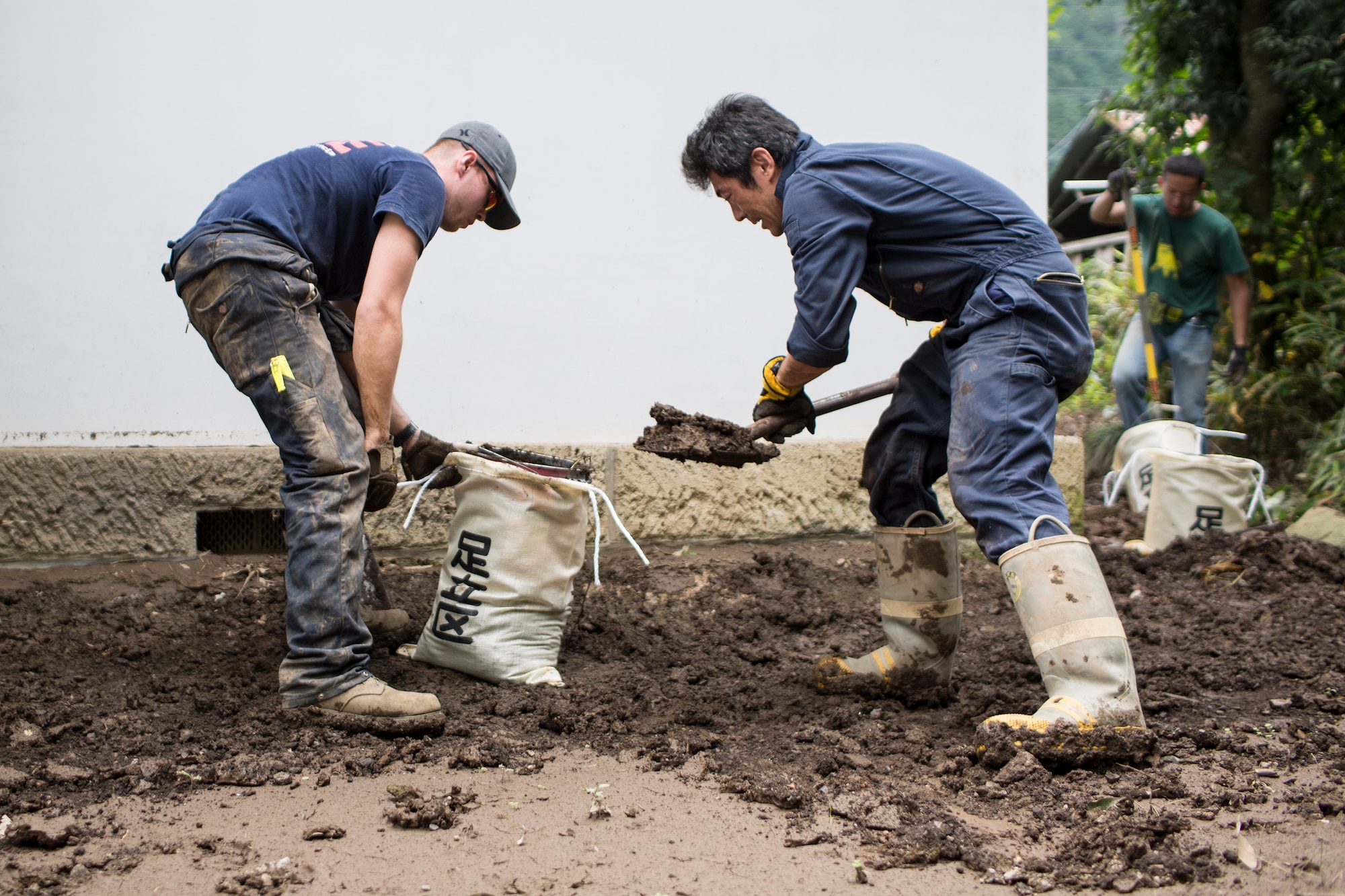 (Left to right) Airman 1st Class Zachary Schofield and Masanobu Ishikawa, both from the 374th Civil Engineer Squadron fire department, clean mudflow from a house at Kanuma City, Tochigi Prefecture, Japan, Sept. 15, 2015. Sixty Airmen and civilians from the 374th CES volunteered to help at sites in the Kasono area in support of floods and landslides caused by the heavy rainfall associated with the post-tropical remnant of Tropical Storm Etau, which stalled over eastern Ja-pan, dumping up to 17 inches of rain in 24 hours, from Sept. 10 to Sept. 11. (U.S. Air Force pho-to by Osakabe Yasuo/Released)