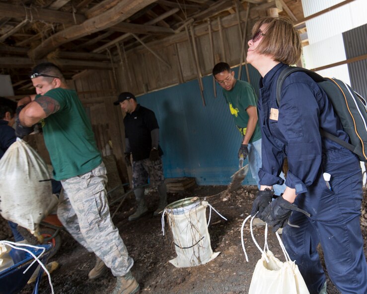 Volunteers from the 374th Civil Engineer Squadron carry bags full of mud from a house at Kanuma City, Tochigi Prefecture, Japan, Sept. 15, 2015. Sixty Airmen and civilians from the 374th CES volunteered to help at sites in the Kasono area in support of floods and landslides caused by the heavy rainfall associated with the post-tropical remnant of Tropical Storm Etau, which stalled over eastern Japan, dumping up to 17 inches of rain in 24 hours, from Sept. 10 to Sept. 11. (U.S. Air Force photo by Osakabe Yasuo/Released)