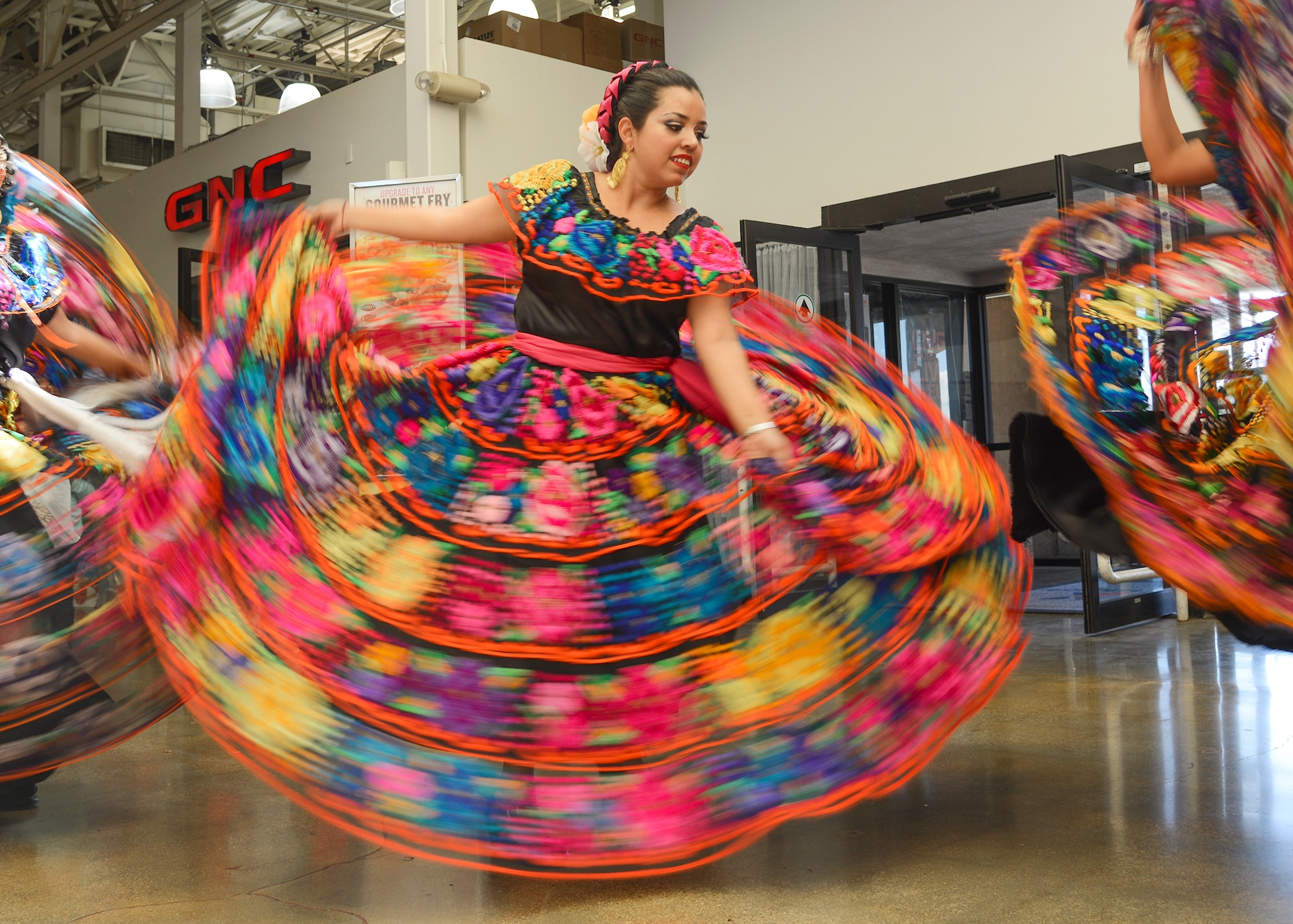 Ana Robles of Ballet Folklorico Etzatlan from Littlerock, California, dances in a vibrant dress to a song from the State of Chiapas, Mexico, an area that is known for its bright colors. Team Edwards kicked off Hispanic Heritage Month Sept. 15 with a Mexican dance display and cake at the Base Exchange.  (U.S. Air Force photo by Rebecca Amber)