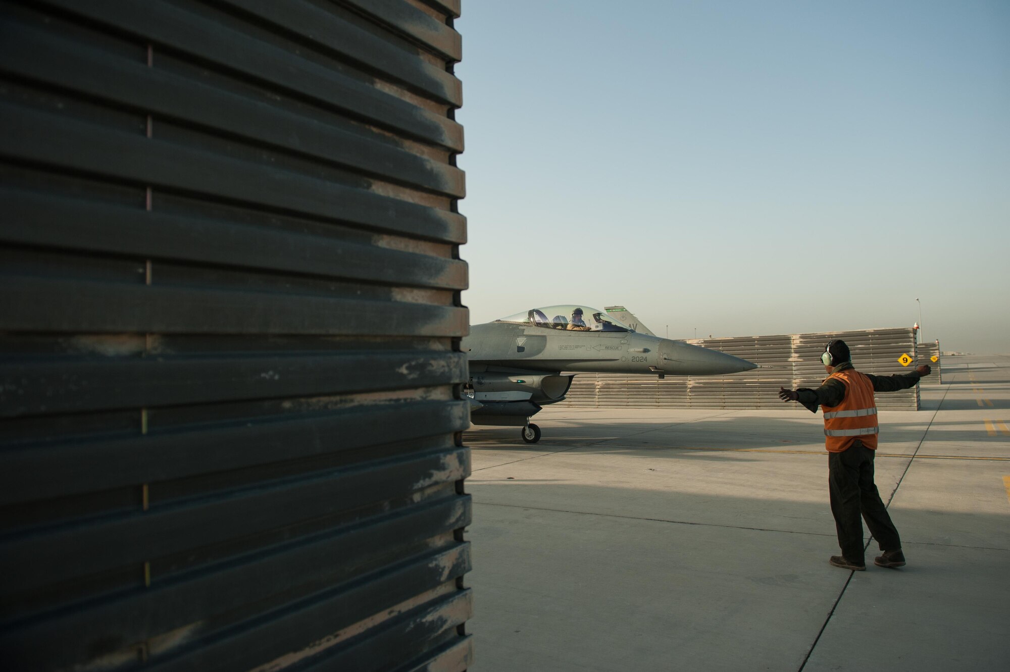 A U.S. Airman assigned to the 455th Expeditionary Aircraft Maintenance Squadron marshals an F-16 Fighting Falcon aircraft before it flies a combat sortie at Bagram Airfield, Afghanistan, Sept. 15, 2015. The 455th EAMXS ensure Fighting Falcons on Bagram are prepared for flight and return them to a mission-ready state once they land.  (U.S. Air Force photo by Tech. Sgt. Joseph Swafford/Released)