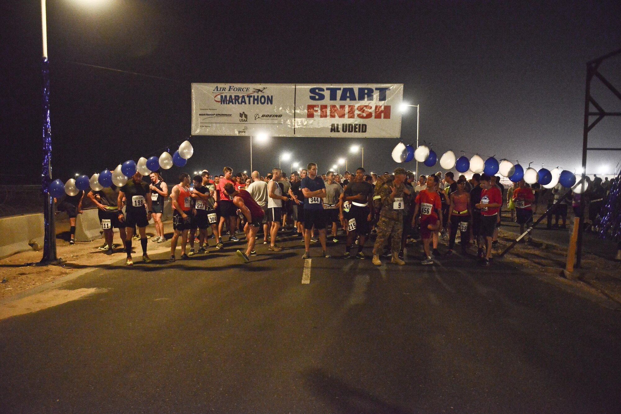 Runners stretch and line up as they wait to start the 2015 Air Force Marathon Forward September 13, 2015 at Al Udeid Air Base, Qatar. This will mark seven years that the race has taken place at seven operating bases in theater. The first Air Force Marathon was held in 1997 at Wright-Patterson Air Force Base, Ohio. Since then, each marathon has been held the third Saturday of September, with an aircraft chosen each year to represent Air Force history in flight. (U.S. Air Force photo/ Staff Sgt. Alexandre Montes) 