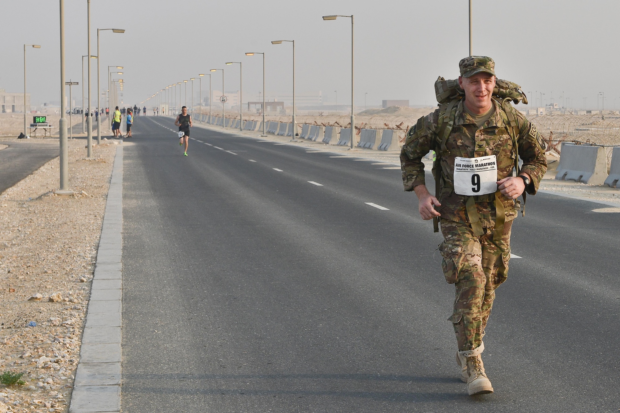 Col. Arno Bischoff, 1st Expeditionary Civil Engineer Group commander, runs towards the finish line to complete his 10K ruck run during the 2015 Air Force Marathon Forward September 13, 2015 at Al Udeid Air Base, Qatar. This will mark seven years of U.S Air Force deployed location races overseas at seven operating bases in theater. The first Air Force Marathon was held in 1997 at Wright-Patterson Air Force Base, Ohio. Since then, each marathon has been held the third Saturday of September, with an aircraft chosen each year to represent Air Force history in flight. (U.S. Air Force photo/ Staff Sgt. Alexandre Montes) 