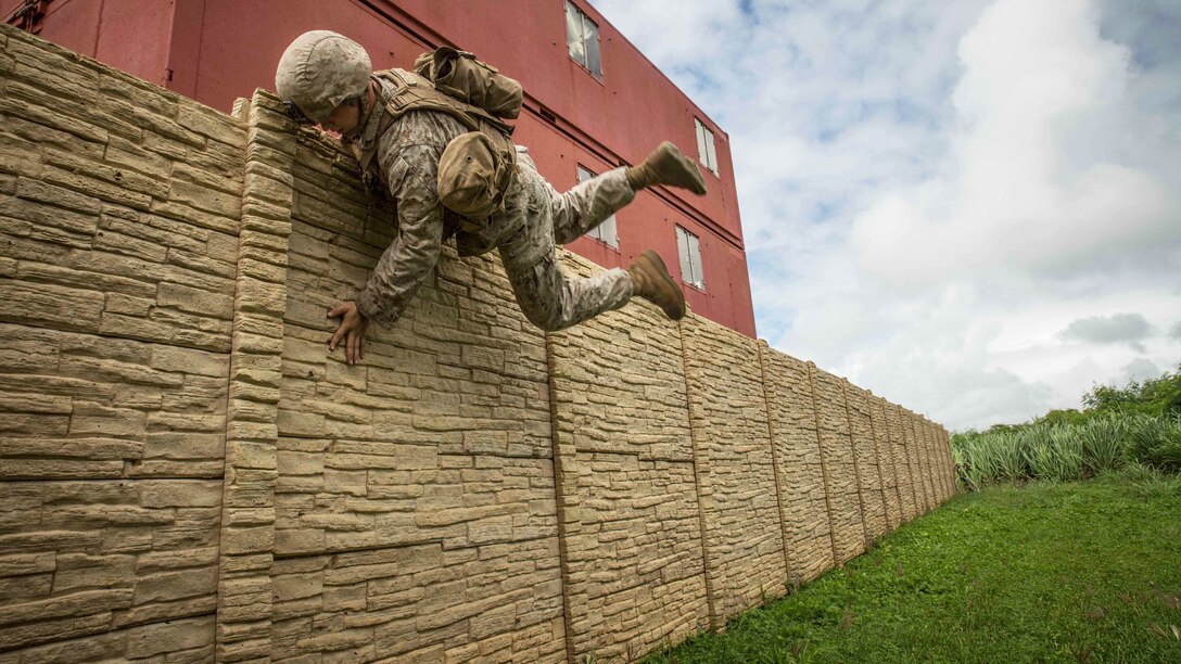 Lance Cpl. Austin Cook, a rifleman with Bravo Company, 1st Battalion, 3rd Marine Regiment and a Columbia, Conn. native, jumps over a wall during military operations in urban terrain training at Training Area Boondocker aboard Marine Corps Base Hawaii, Sept. 15, 2015. Bravo Company was conducting sustainment training to ensure they keep their combat mindset sharp and intact before embarking on their upcoming Unit Deployment Program. Training like this supports the mission of Marine Corps Base Hawaii by enhancing and sustaining combat readiness. 