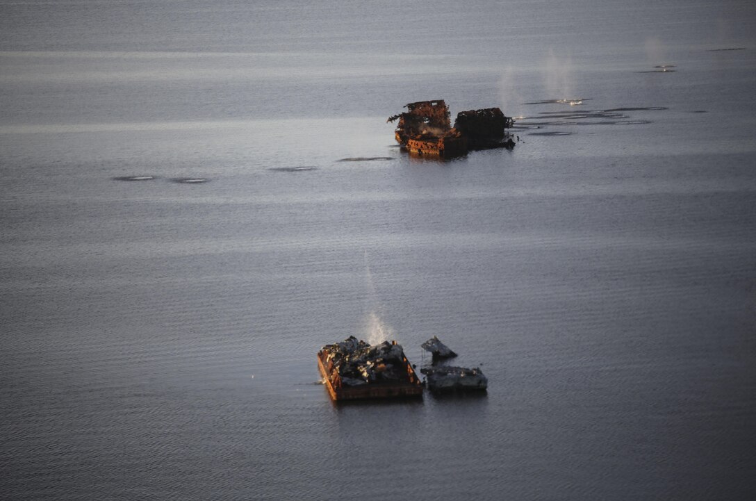 Marines with Marine Medium Tiltrotor Squadron 365 make impact on targets utilizing the GAU-16 .50 caliber machine gun in an MV-22B Osprey in the skies above Piney Island bombing range, Sept. 15, 2015. The crew flew over training area Bombing Target 11 to assault targets resembling a convoy, barge and landing craft. (U.S. Marine Corps photo by Cpl. Paul S. Martinez/Released)