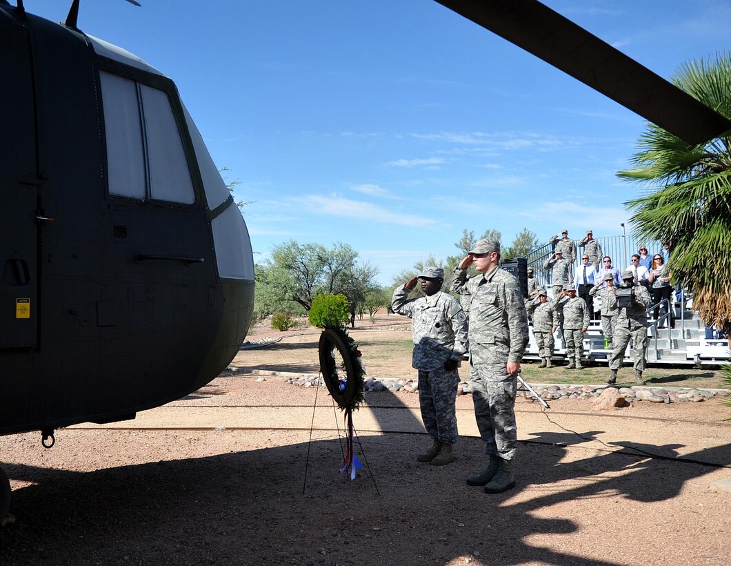Army Staff Sergeant Maurice Liggins, a recruiter from the Tucson Recruiting Company, and Senior Airman Christopher Martin, 305th Rescue Squadron aviation resource manager render salutes at the static display model of a CH-3E Jolly Green Giant helicopter similar to the own flown by the aircrew of flight PONY 1-2 at Heritage Park, Davis-Monthan AFB. 943rd RQG Airmen past and present gathered to remember the men who died during a nighttime training mission aboard a CH-3E Jolly Green Giant Helicopter. (U.S. Air Force Photo/ Tech. Sgt. Carolyn Herrick)