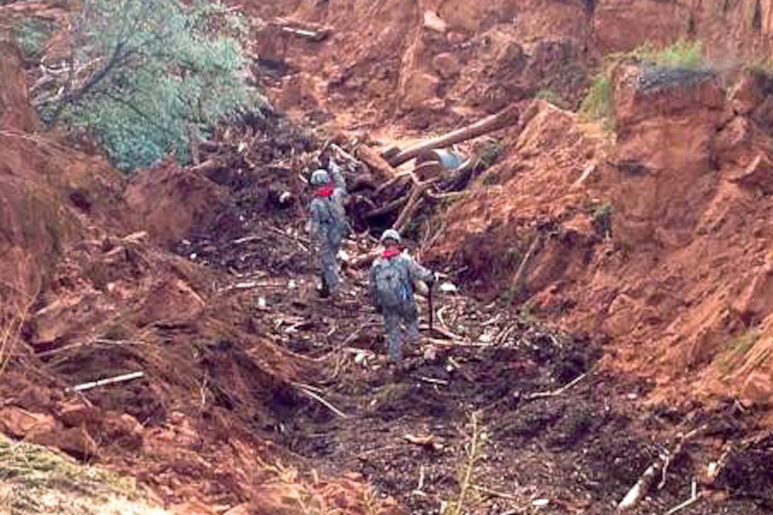 Utah Army National Guardsmen conduct their search and rescue efforts for survivors in a ravine following the deadly flooding near the border town of Hildale, Utah, Sept. 16, 2015.
