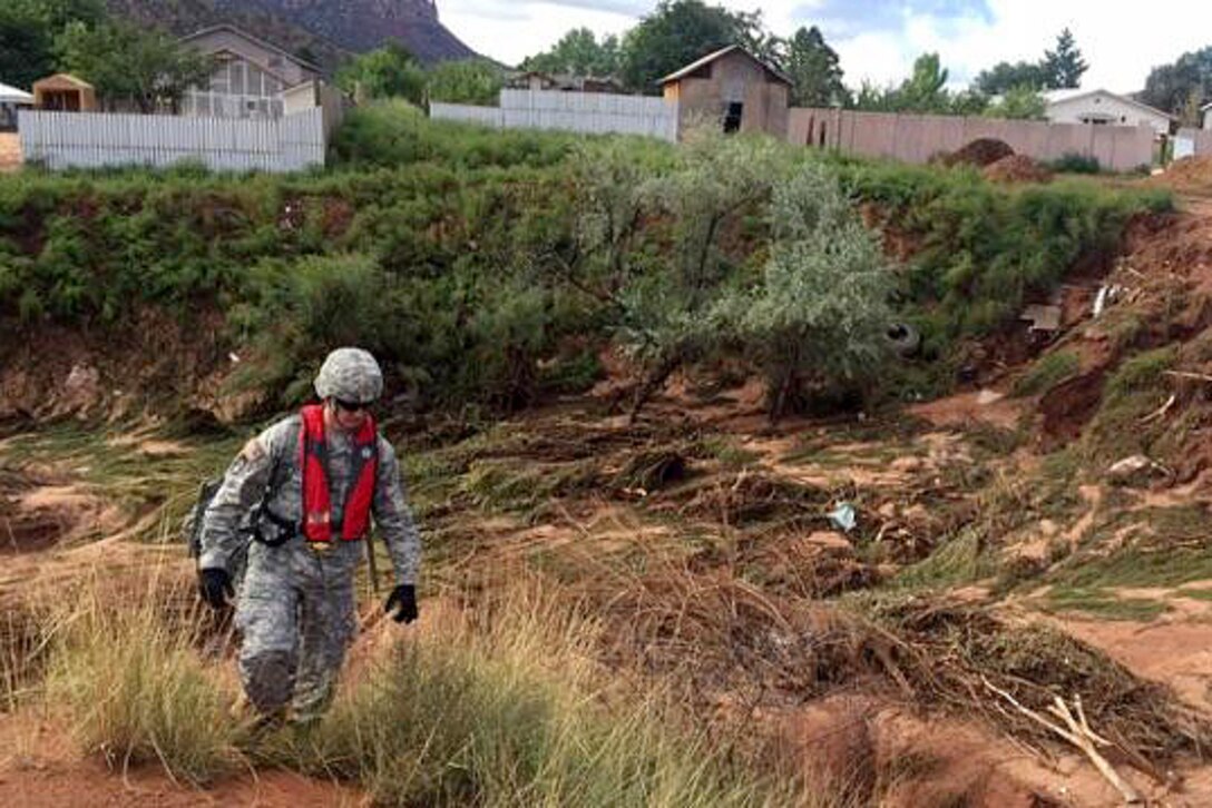 A Utah Army National Guardsman conducts search and rescue efforts for survivors following the deadly flooding near the border town of Hildale, Utah, Sept. 16, 2015.