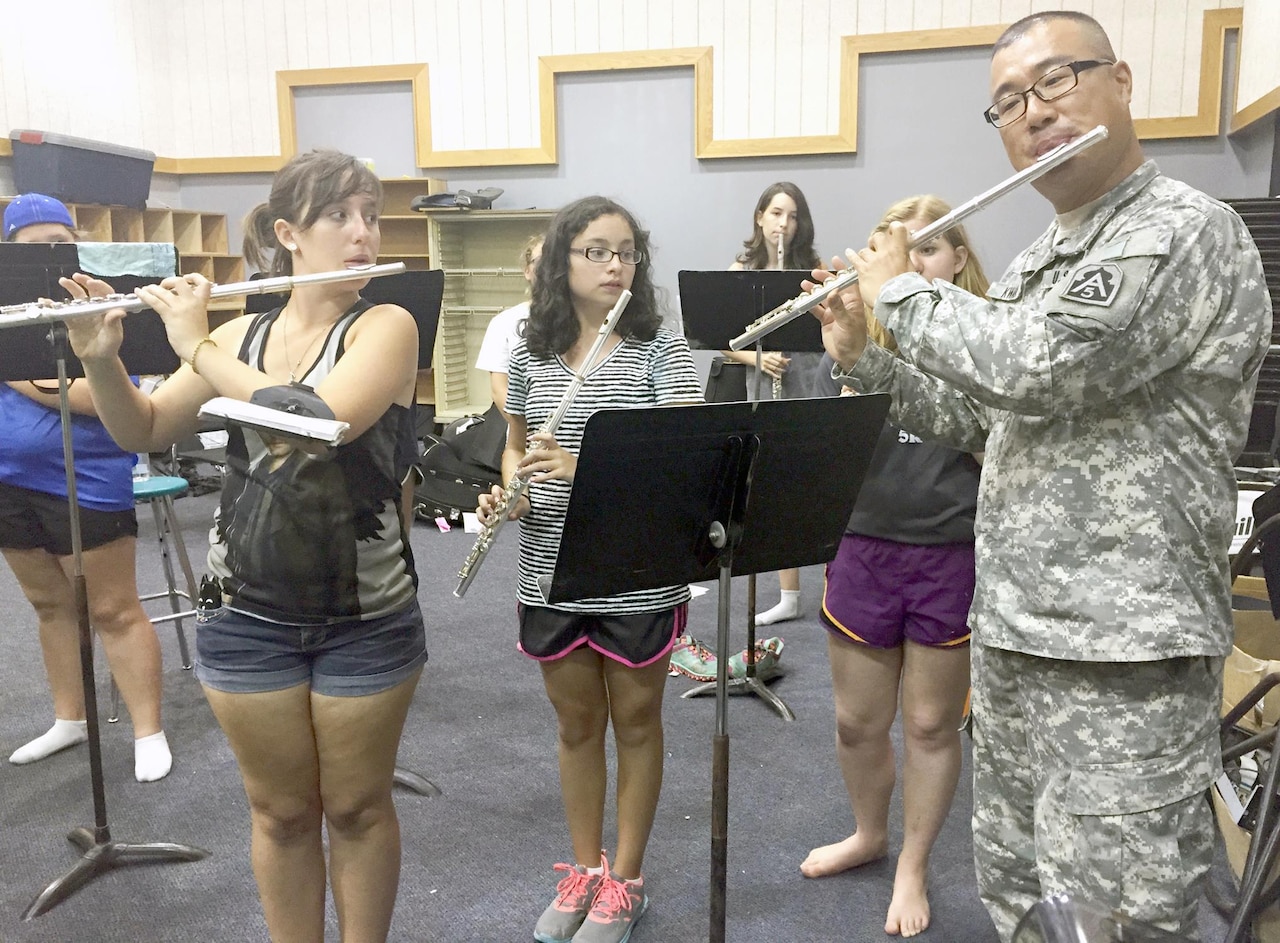 Army Spc. Michael Kwak, 323rd Army Band flutist, leads flute players through a selection of music in Texas during La Vernia High School's annual summer band camp held Aug. 3-7, 2015. U.S. Army photo by Sgt. Christian A. Turner