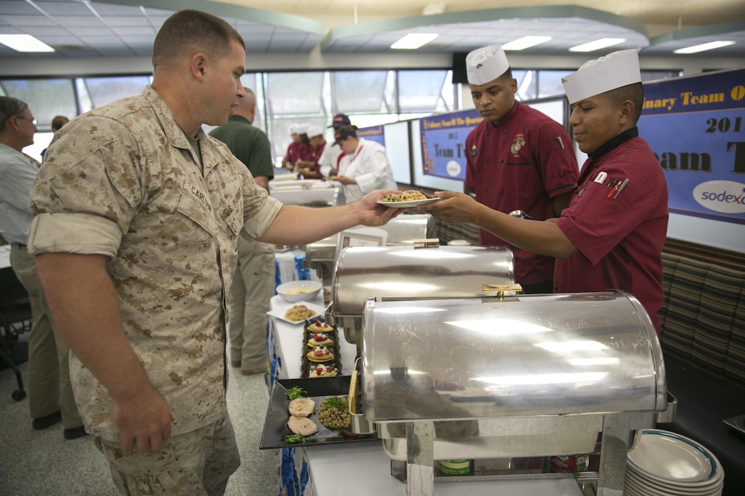 Lance Cpl. Marco Perry, food service specialist, 1st Tank Battalion, serves his dishes to Combat Center Marines and sailors during the Chef of the Quarter Competition at Phelps Mess Hall, Sept. 16, 2015. Marines and sailors voted for the team with the highest quality dishes. (Official Marine Corps photo by Lance Cpl. Levi Schultz/Released)