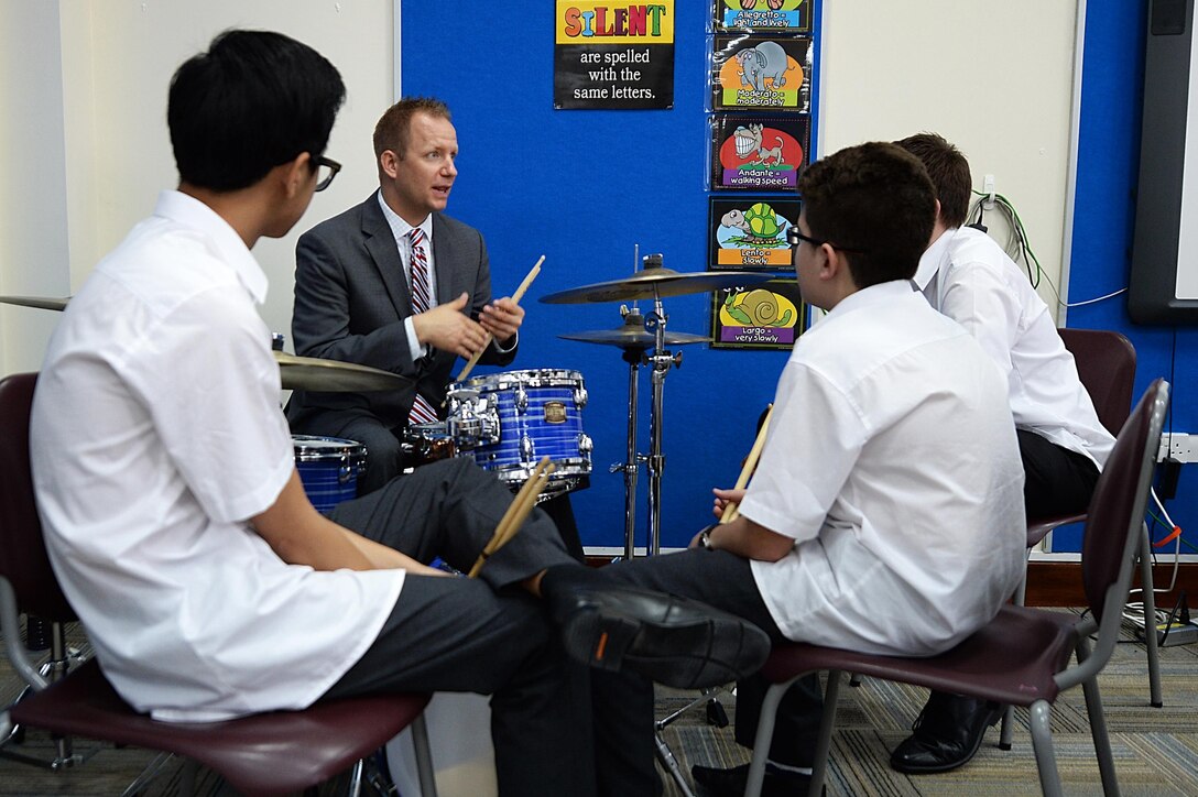 Tech. Sgt. Bennett Weidemann, Air Forces Central Command band drummer, teaches students about drumming during a mentoring session at the Qatar Academy, Doha, Qatar, Sept. 14, 2015. In addition to performing throughout the day, the Airmen answered questions about being professional musicians in the Air Force and held a mentoring session for aspiring musical students. (U.S. Air Force photo by Staff Sgt. Emerson Nuñez/Released)
