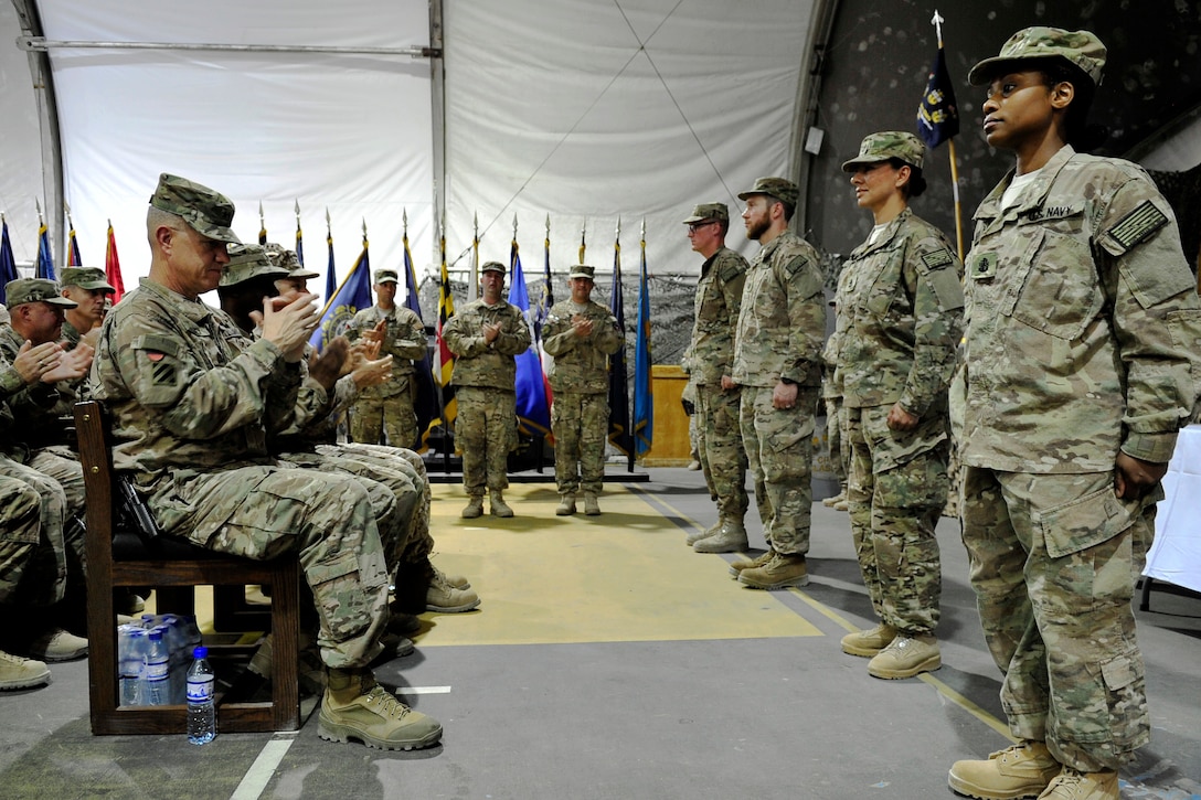Newly pinned U.S. Navy chief petty officers are congratulated by U.S. Army Maj. Gen. James Rainey, left, deputy commander, U.S. Forces – Afghanistan, along with U.S. and coalition troops after a chief pinning ceremony on Bagram Airfield, Afghanistan, Sept. 16, 2015. Seven Navy chief petty officers received their anchors while serving as individual augmentees in Afghanistan. U.S. Navy photo by Lt. Kristine Volk