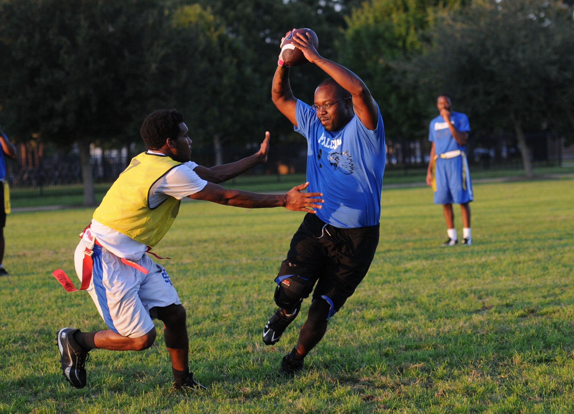 Michael Doss, 81st Medical Operations Squadron, reaches out for the flags of Tech. Sgt. Demareo Smith, 81st Training Support Squadron, as he runs the ball during an intramural flag football scrimmage Sept. 15, 2015, Keesler Air Force Base, Miss. The season began Sept. 9 and runs through mid-November. (U.S. Air Force photo by Kemberly Groue)