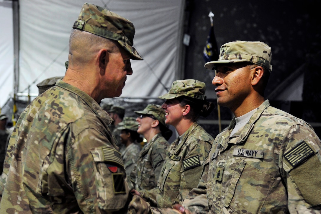 U.S. Army Maj. Gen. James Rainey, left, deputy commander, U.S. Forces – Afghanistan, congratulates newly pinned U.S. Navy Chief Petty Officer Edson Anaya, after a chief pinning ceremony on Bagram Airfield, Afghanistan, Sept. 16, 2015. Anaya is a hospital corpsman assigned to the Role 3 Multinational Medical Unit based at Kandahar Airfield, is one of seven chief petty officers receiving anchors while serving in Afghanistan. U.S. Navy photo by Lt. Kristine Volk