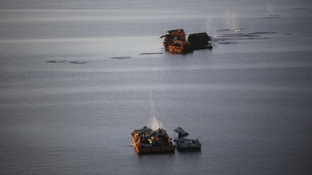 Marines with Marine Medium Tiltrotor Squadron 365 make impact on targets utilizing the GAU-16 .50 caliber machine gun in an MV-22B Osprey in the skies above Piney Island bombing range, North Carolina, Sept. 15, 2015. The crew flew over training area Bombing Target 11 to assault targets resembling a convoy, barge and landing craft. 