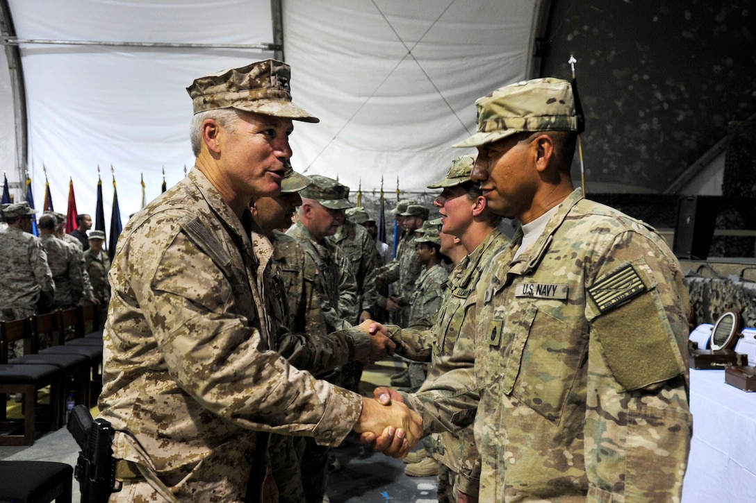 U.S. Navy Capt. Duncan Smith, left, U.S. Navy SEAL, congratulates newly pinned U.S. Navy Chief Petty Officer Edson Anaya, after a chief pinning ceremony on Bagram Airfield, Afghanistan, Sept. 16, 2015. Anaya is a hospital corpsman assigned to the Role 3 Multinational Medical Unit based at Kandahar Airfield, is one of seven chief petty officers receiving anchors while serving in Afghanistan. U.S. Navy photo by Lt. Kristine Volk